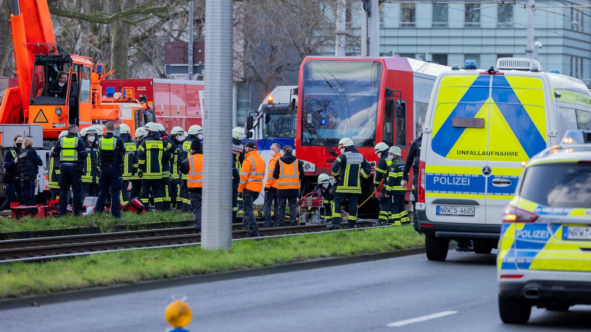 Einsatzkräfte stehen an einer Straßenbahn.