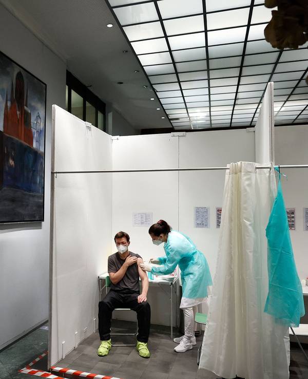 Eine Ärztin impft den Patienten Andre Wermter mit der Boosterimpfung mit dem Impfstoff Biontech in der Heilig-Kreuz-Kirche in Kreuzberg.