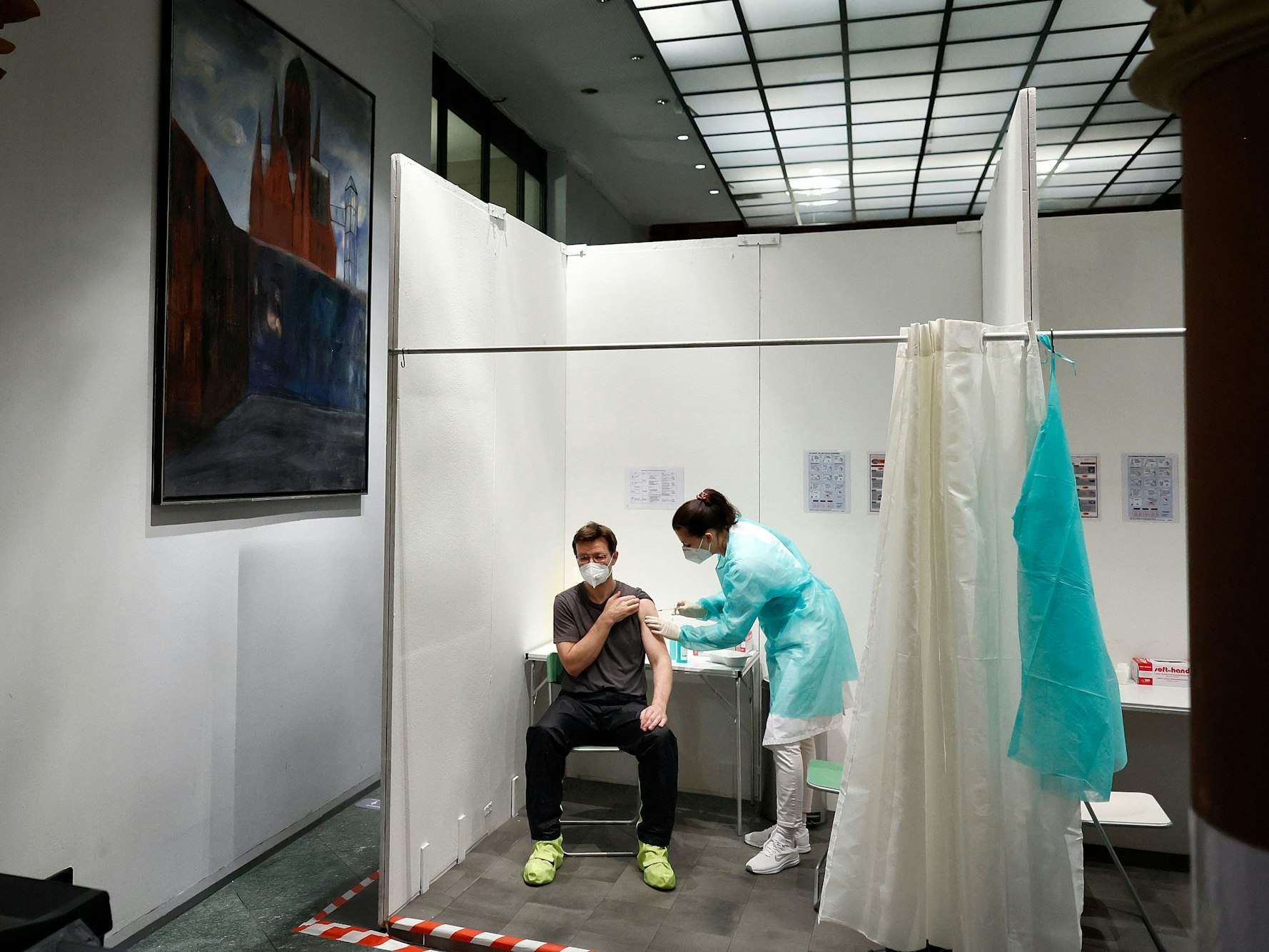 Eine Ärztin impft den Patienten Andre Wermter mit der Boosterimpfung mit dem Impfstoff Biontech in der Heilig-Kreuz-Kirche in Kreuzberg.