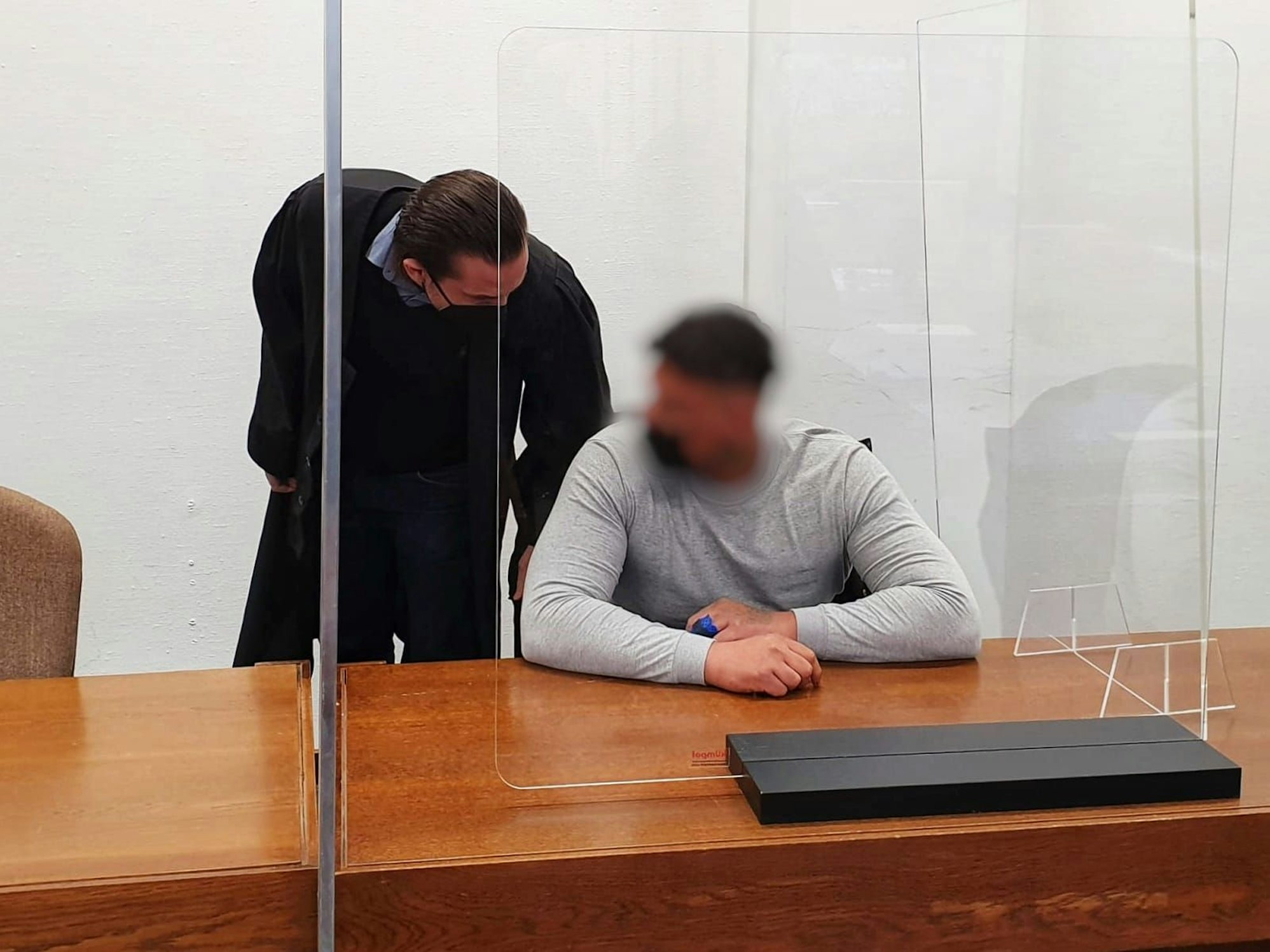 Ein Mann sitzt im Gericht mit seinem Anwalt.