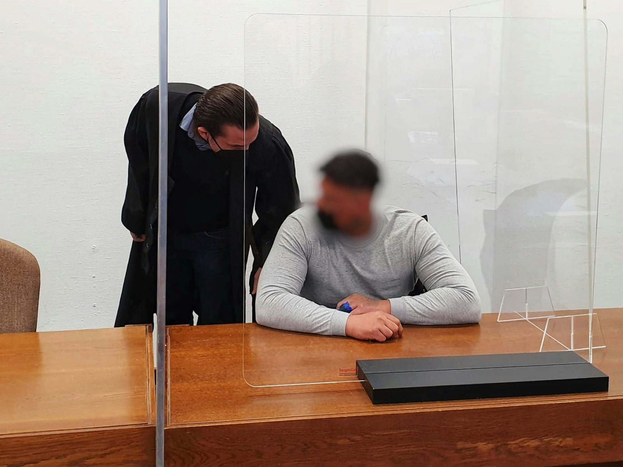 Ein Mann sitzt im Gericht mit seinem Anwalt.