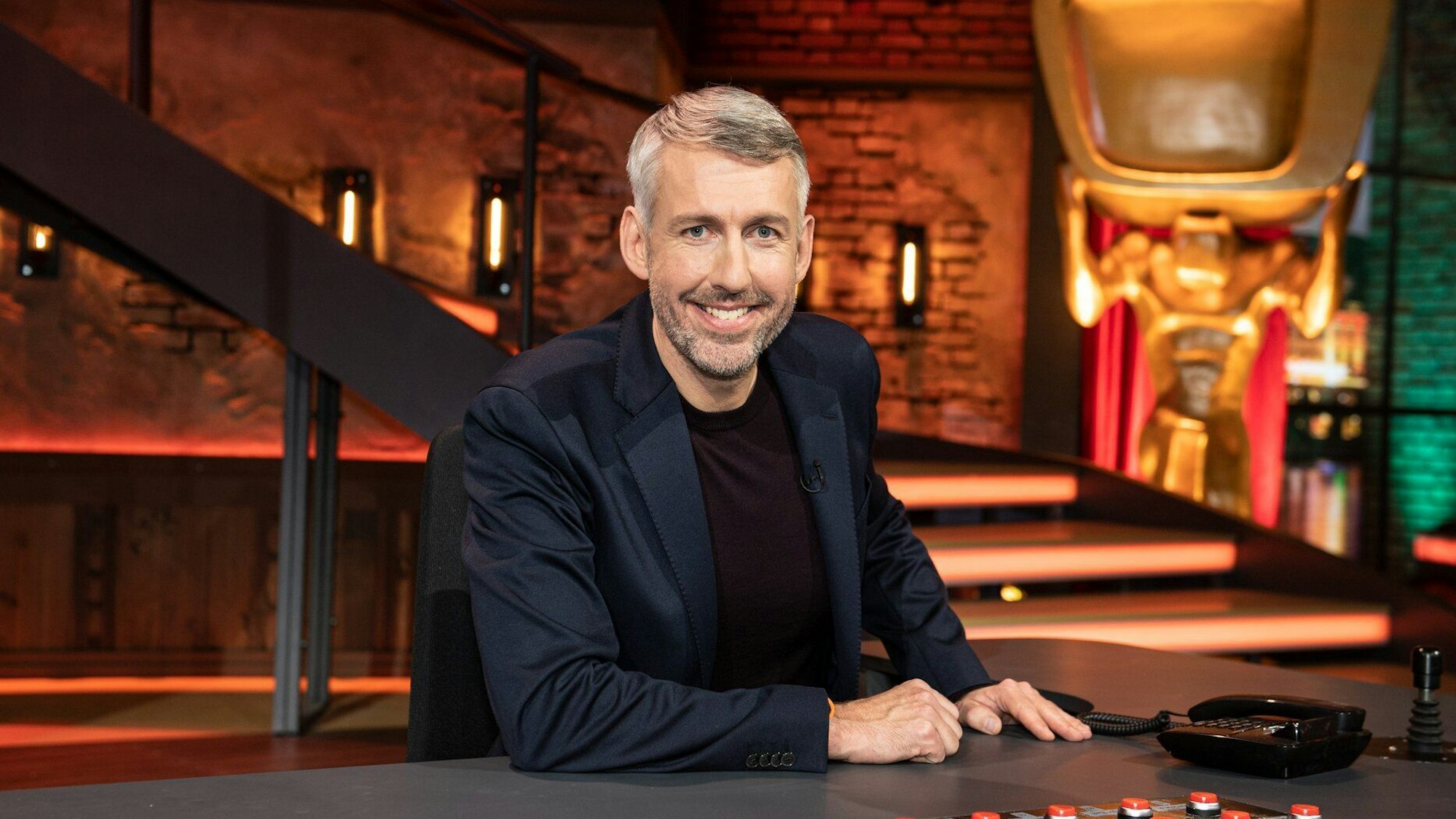 Sebastian Pufpaff sitzt im „TV Total“-Studio hinter seinem Schreibtisch.