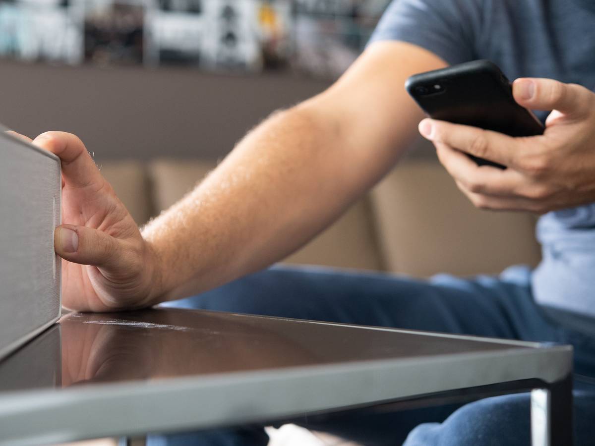 Ein WLAN-Lautsprecher wird über ein Smartphone gestartet.