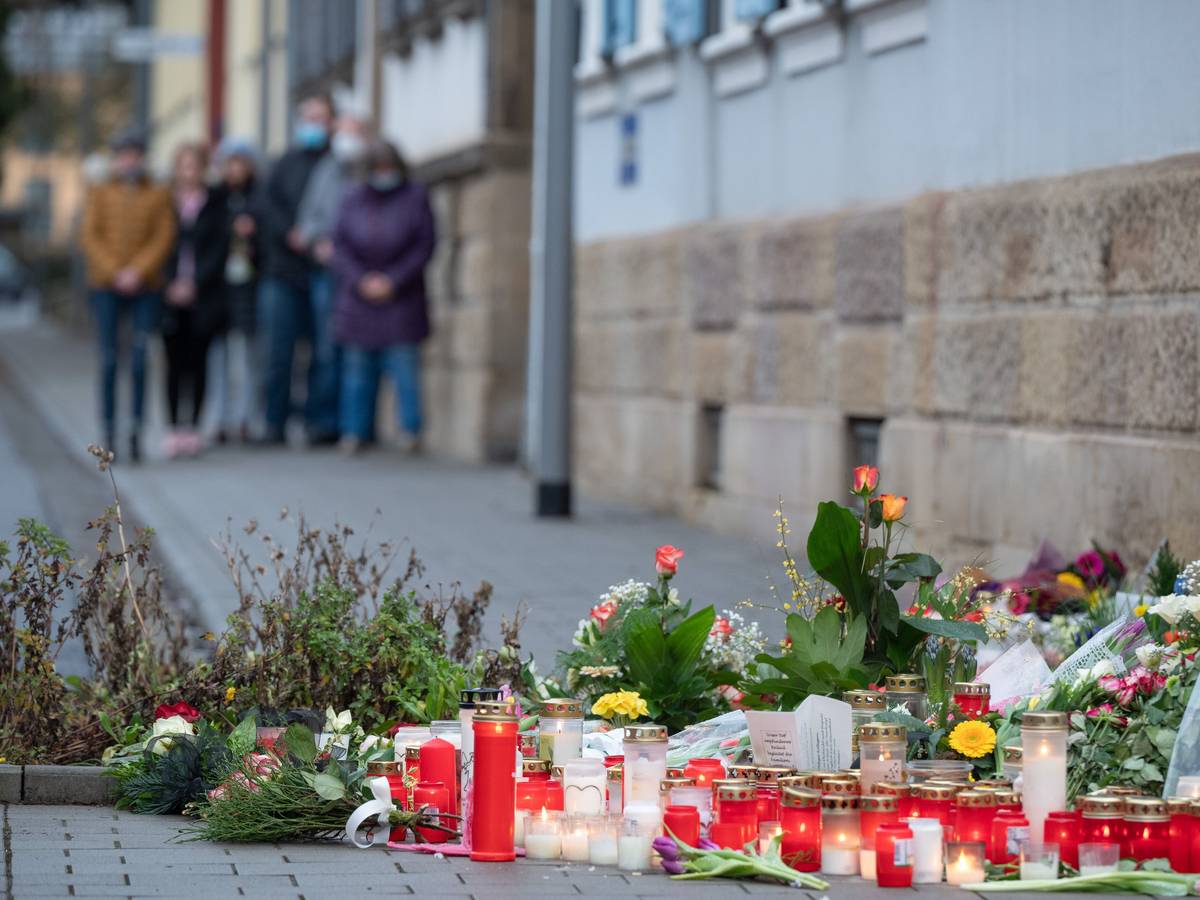 Menschen stehen bei einer Schweigeminute vor der Polizeiinspektion Kusel