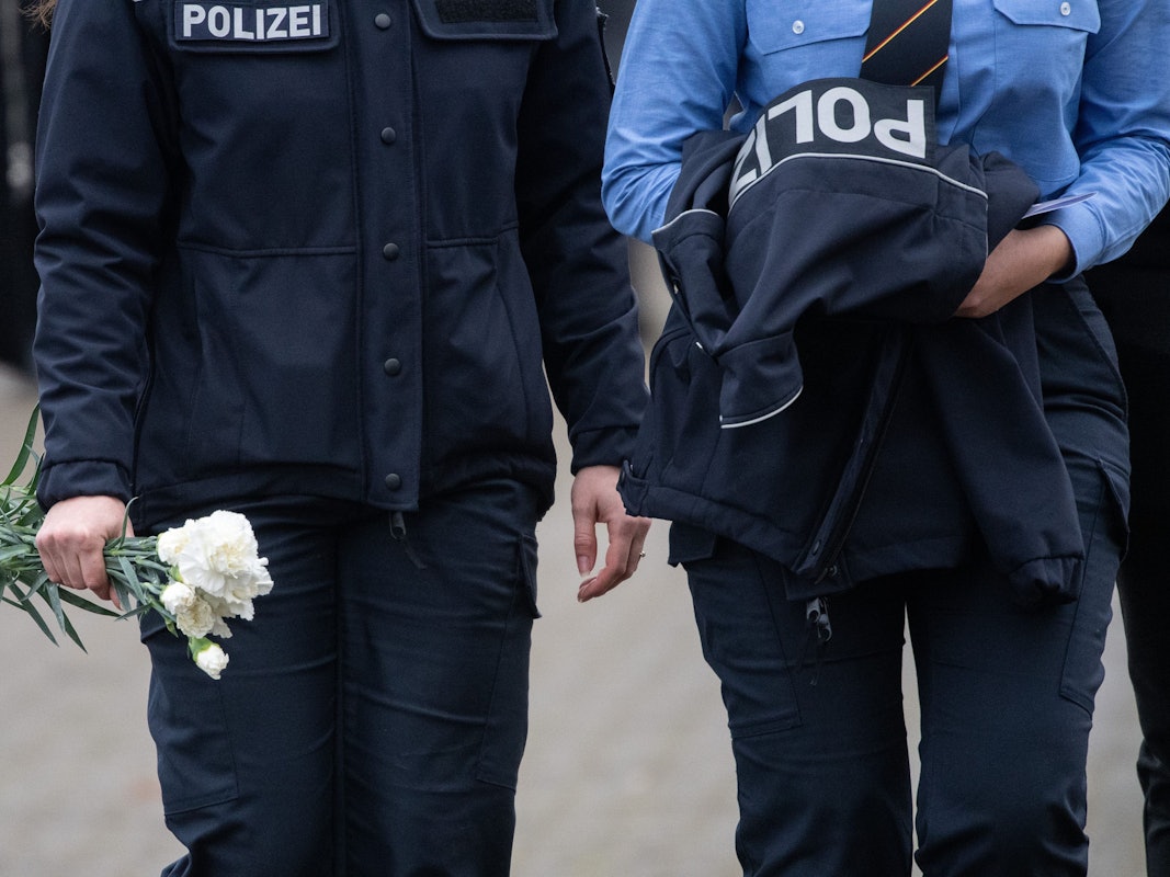 Polizeibeamtinnen mit weißen Nelken