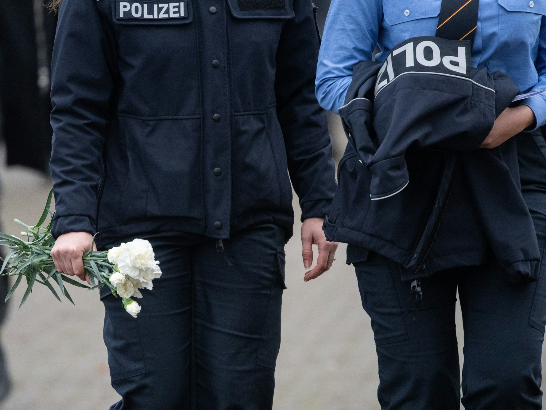 Polizeibeamtinnen mit weißen Nelken