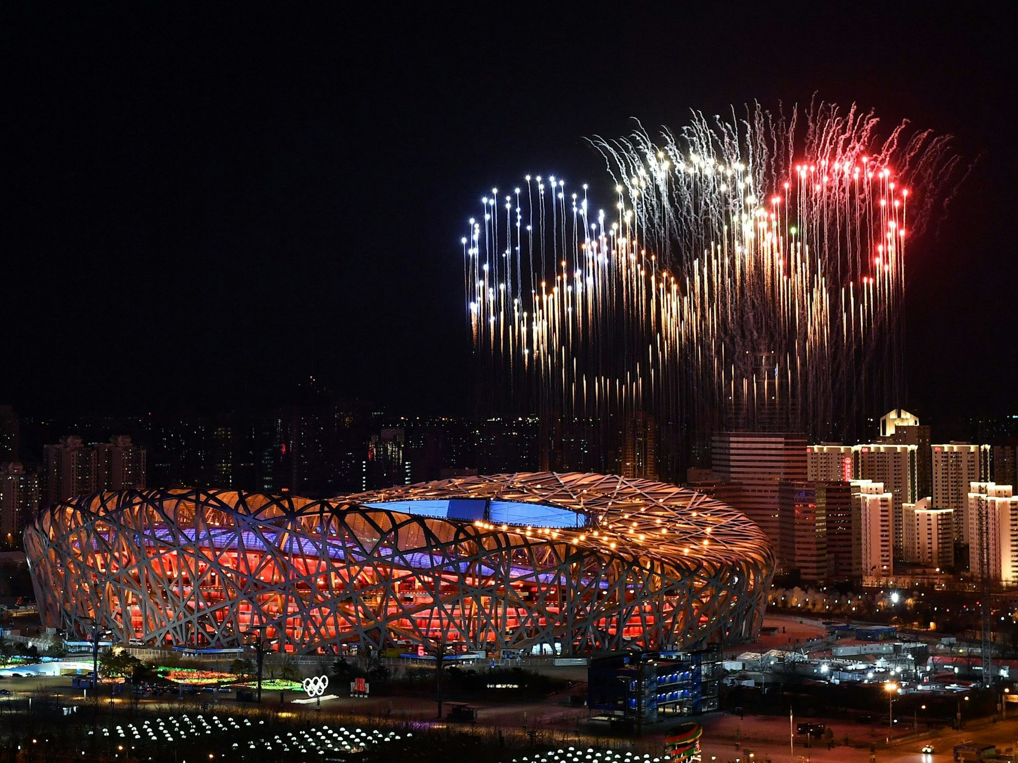 Ein Feuerwerk in Form der olympischen Ringe erhellt den Abend über dem Stadion in Peking.