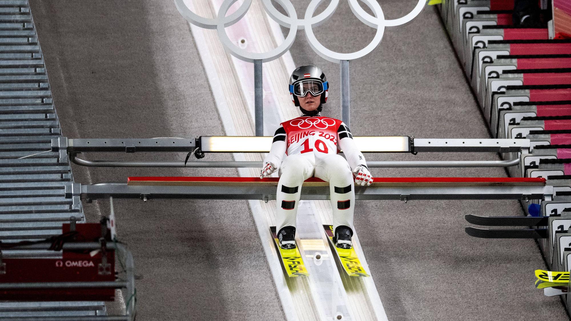 Sophie Sorschag sitzt auf dem Absprungbalken.