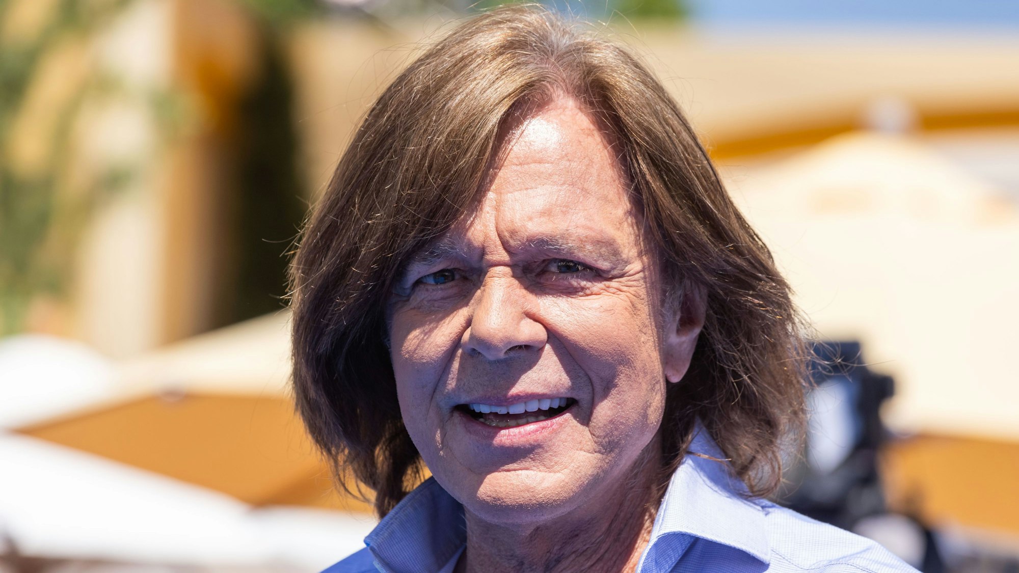 Der Sänger Jürgen Drews geht während der Liveübertragung der Sendung „Immer wieder Sonntags“ über das Set. Der Sänger lächelt dabei in die Kamera