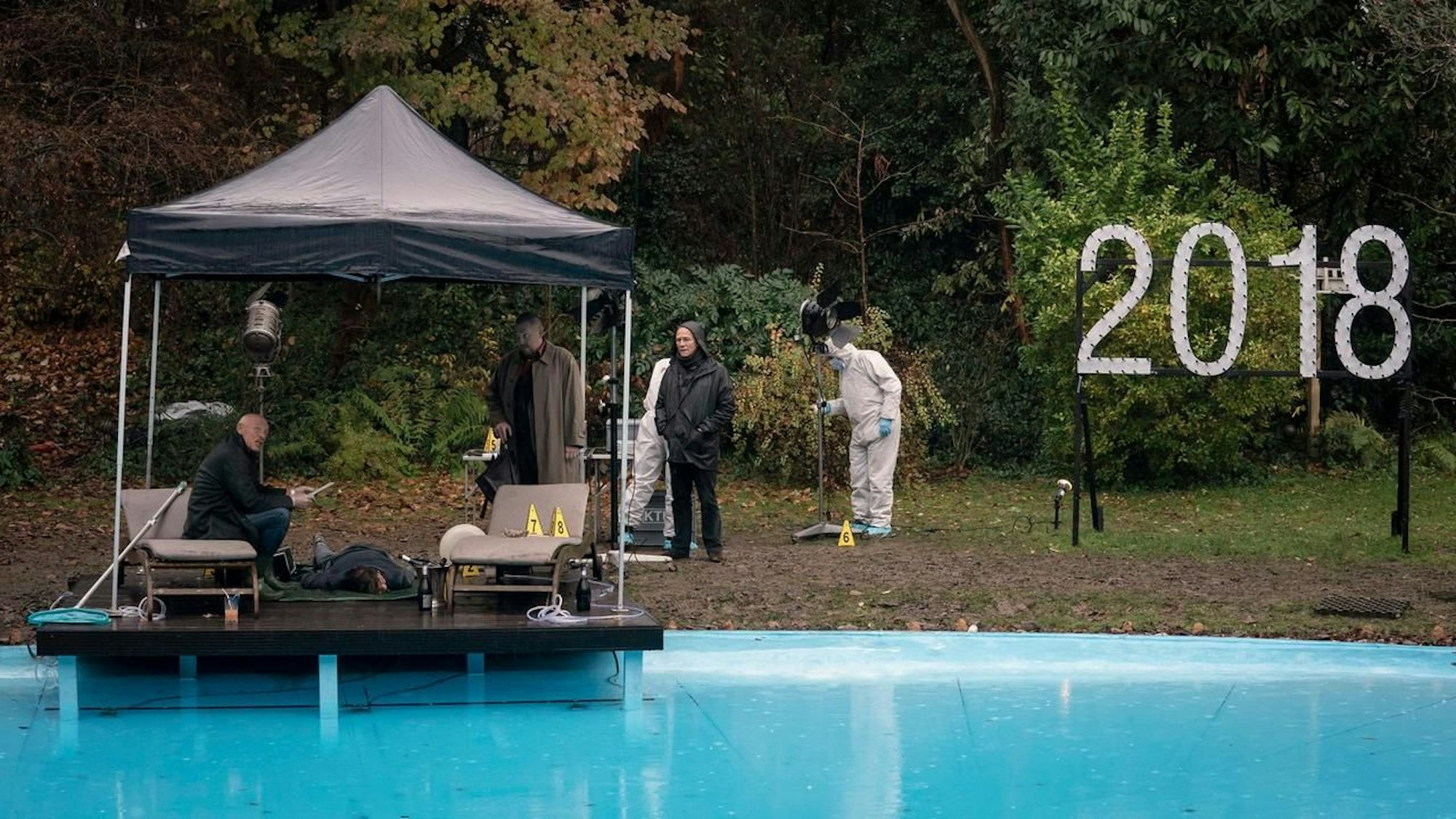 Eine Szene eines Filmsets an einem Swimmingpool.
