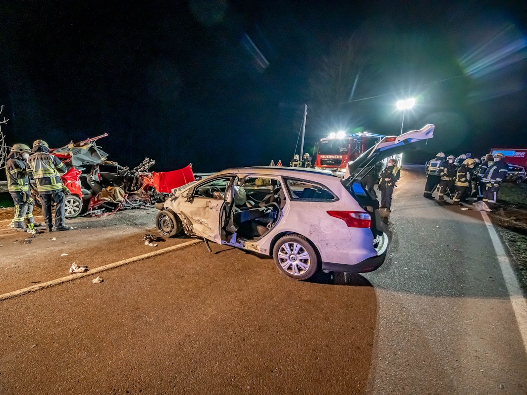 Gummersbach: Feuerwehrleute stehen an der Unfallstelle. Bei einem Autounfall auf einer Landstraße im Märkischen Kreis ist ein junges Paar tödlich verunglückt.