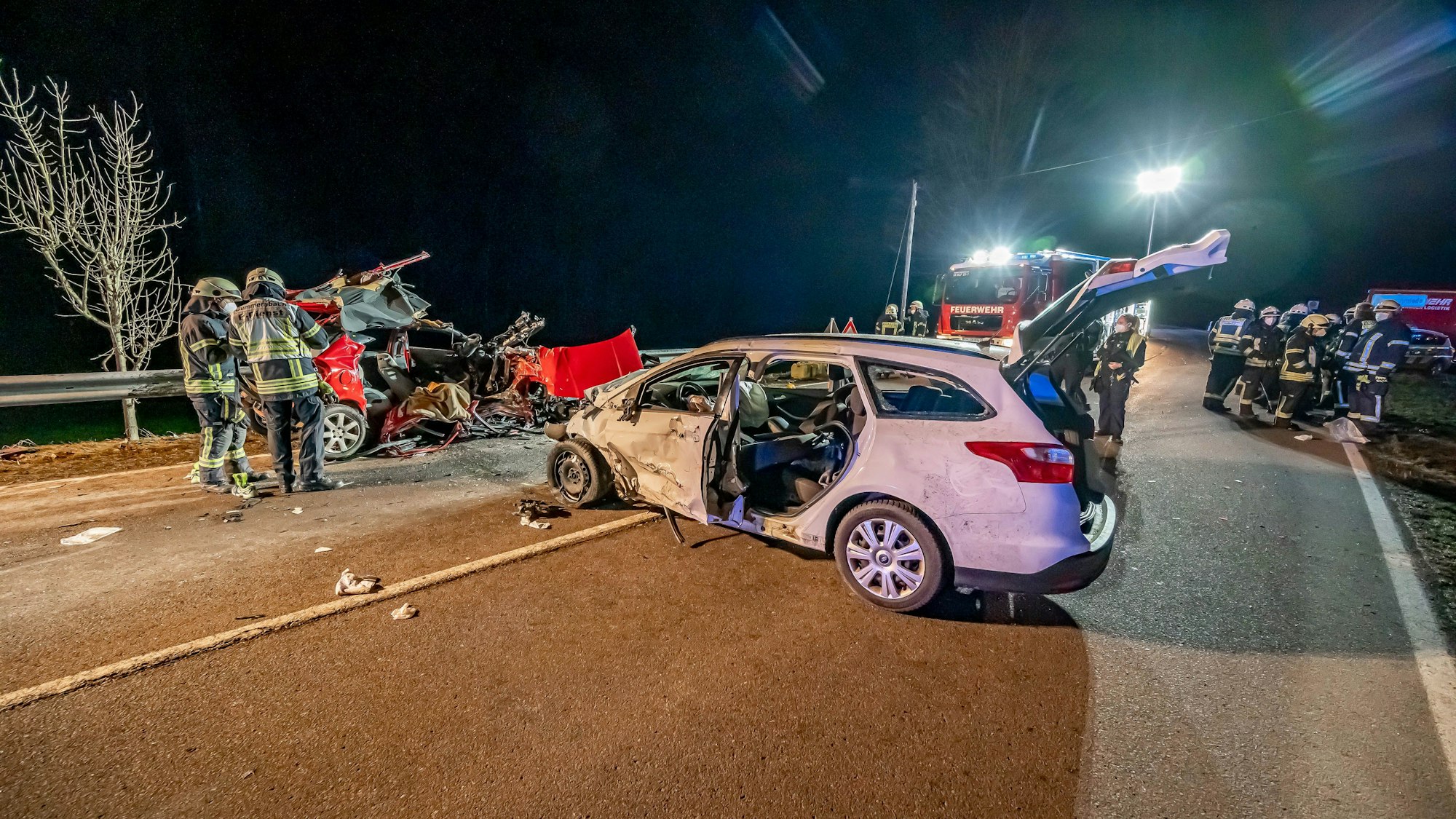 Gummersbach: Feuerwehrleute stehen an der Unfallstelle. Bei einem Autounfall auf einer Landstraße im Märkischen Kreis ist ein junges Paar tödlich verunglückt.