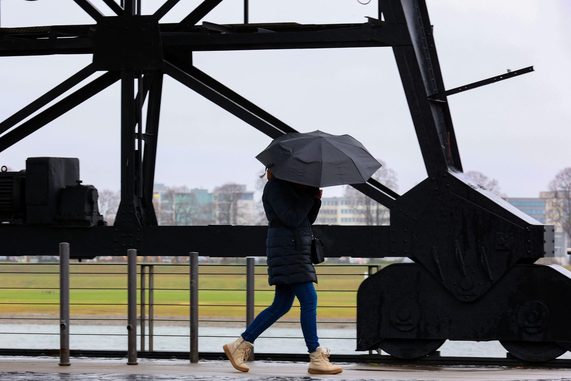 Köln:
Im Rheinauhafen versucht eine Fußgängerin Ihren Schirm fest zu halten.
Anhaltendes stürmisches Regenwetter über Köln.