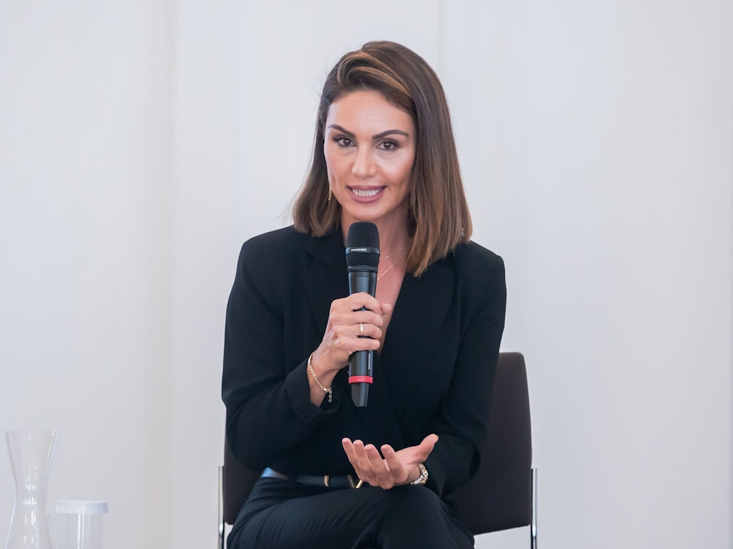 Nazan Eckes, Moderatorin, spricht bei einer Gesprächsveranstaltung mit Bürgerinnen und Bürgern mit türkischen Wurzeln im Schloss Bellevue anlässlich des 60. Jahrestages des deutsch-türkischen Anwerbeabkommens. Sie sitzt auf einem Stuhl und hält sich ein Mikrofon vor den Mund