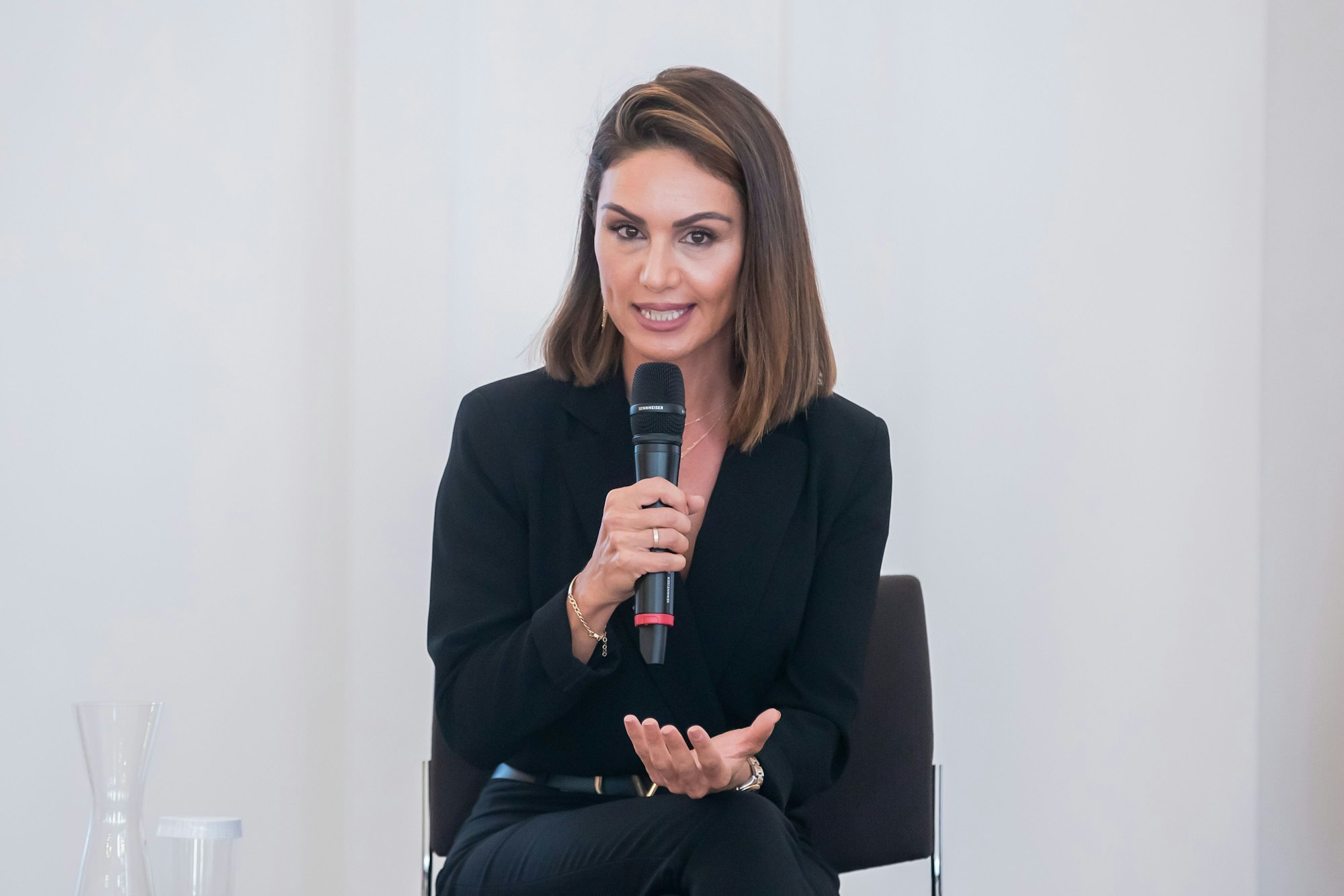 Nazan Eckes, Moderatorin, spricht bei einer Gesprächsveranstaltung mit Bürgerinnen und Bürgern mit türkischen Wurzeln im Schloss Bellevue anlässlich des 60. Jahrestages des deutsch-türkischen Anwerbeabkommens. Sie sitzt auf einem Stuhl und hält sich ein Mikrofon vor den Mund