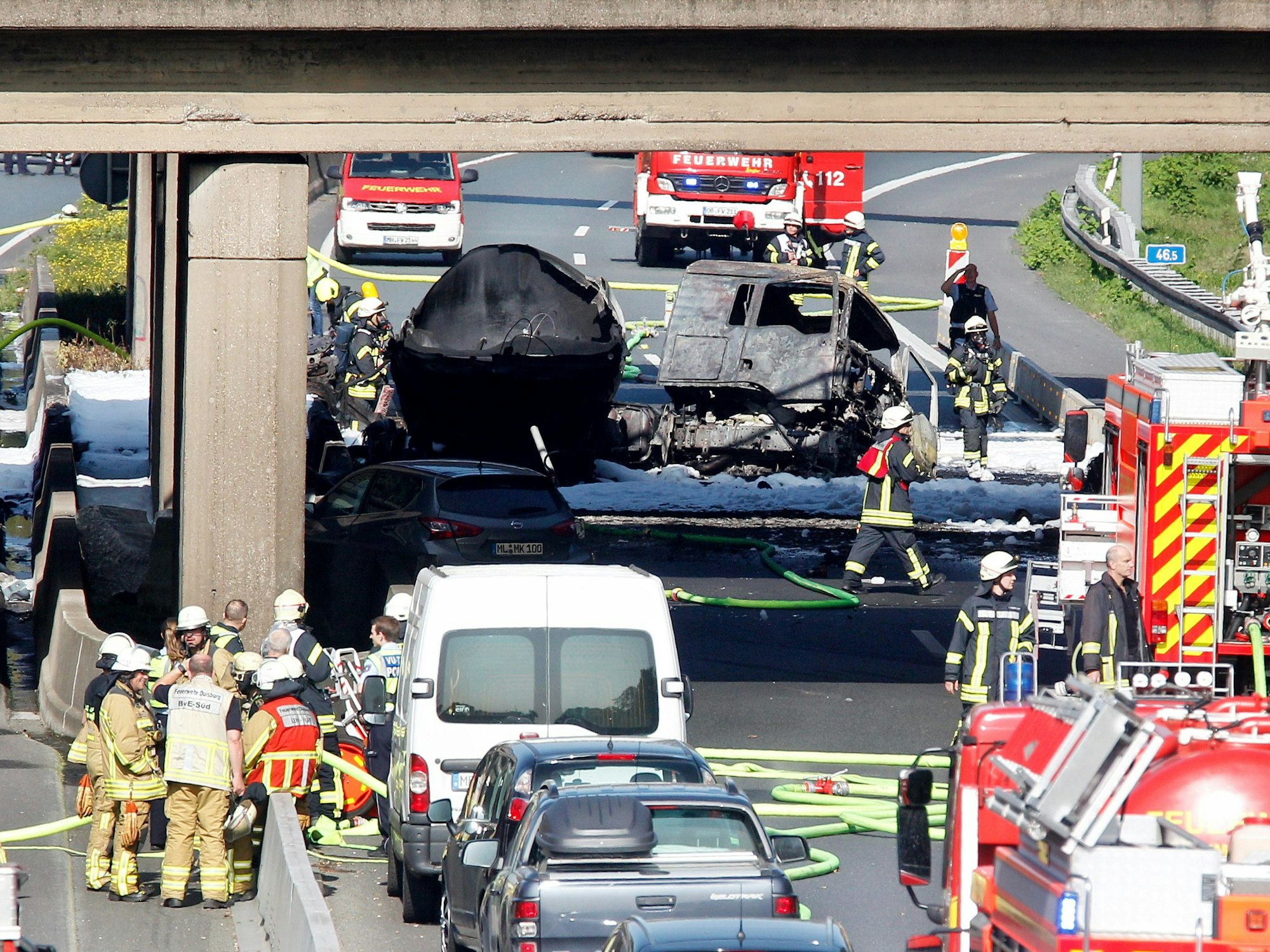 Nordrhein-Westfalen, Mülheim: Feuerwehrleute stehen an dem ausgebrannten Tanklaster auf der A40.
