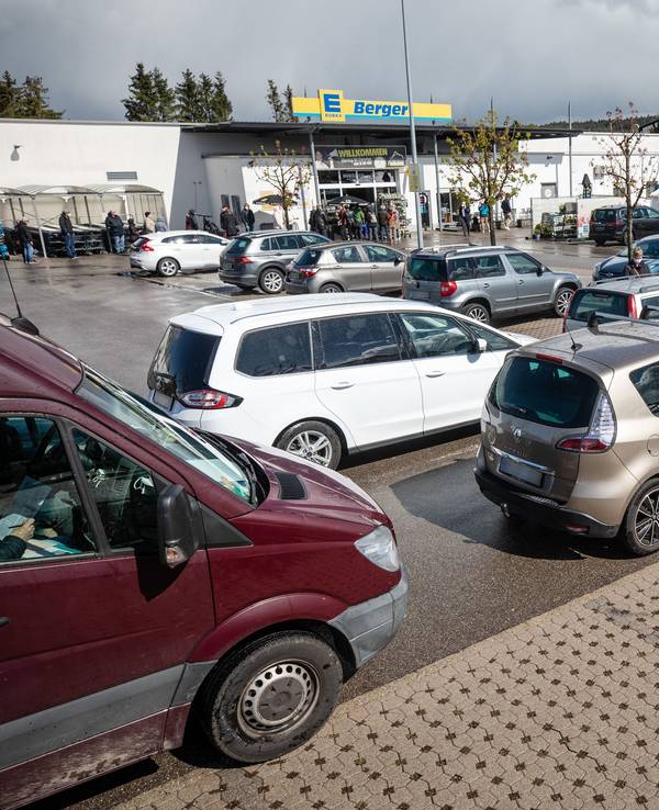 Zu sehen ist ein Edeka-Parkplatz, auf dem mehrere Autos parken.
