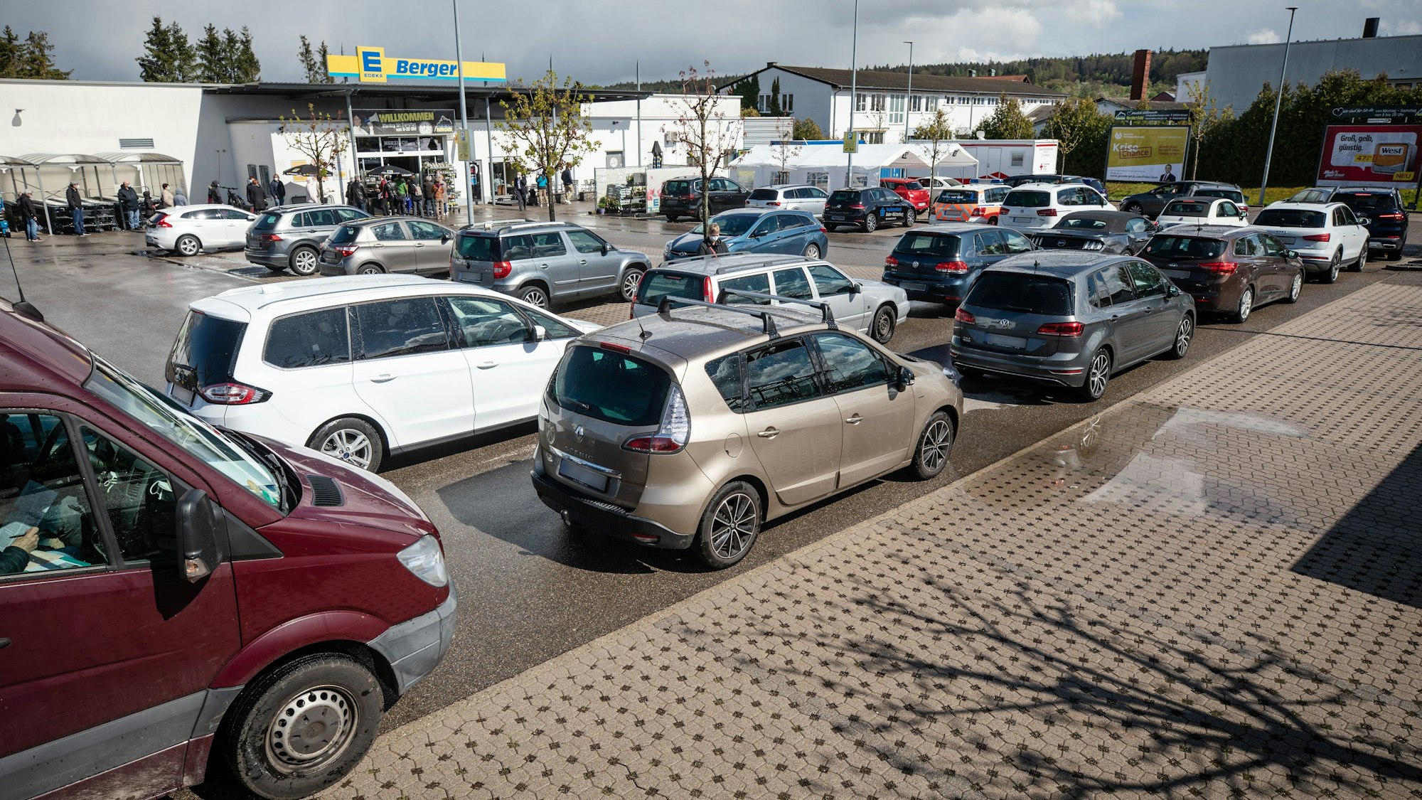Zu sehen ist ein Edeka-Parkplatz, auf dem mehrere Autos parken.