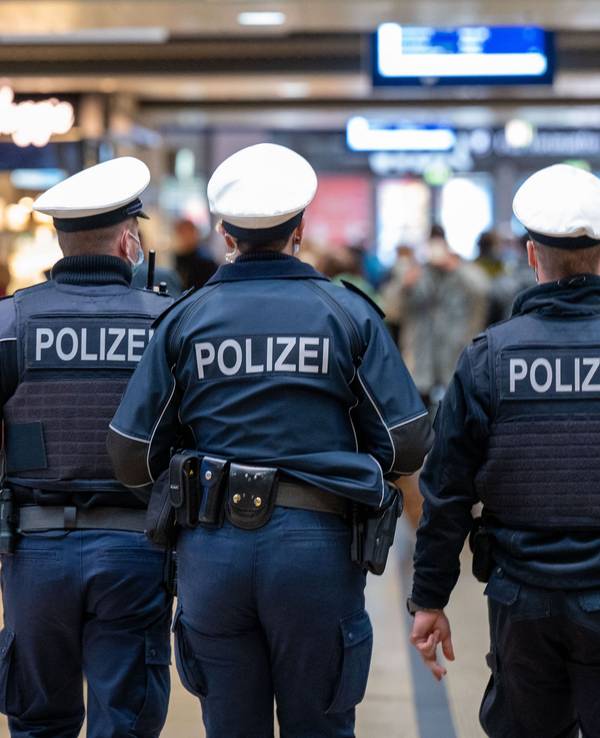 Drei Polizeibeamte laufen durch den Kölner Hauptbahnhof.