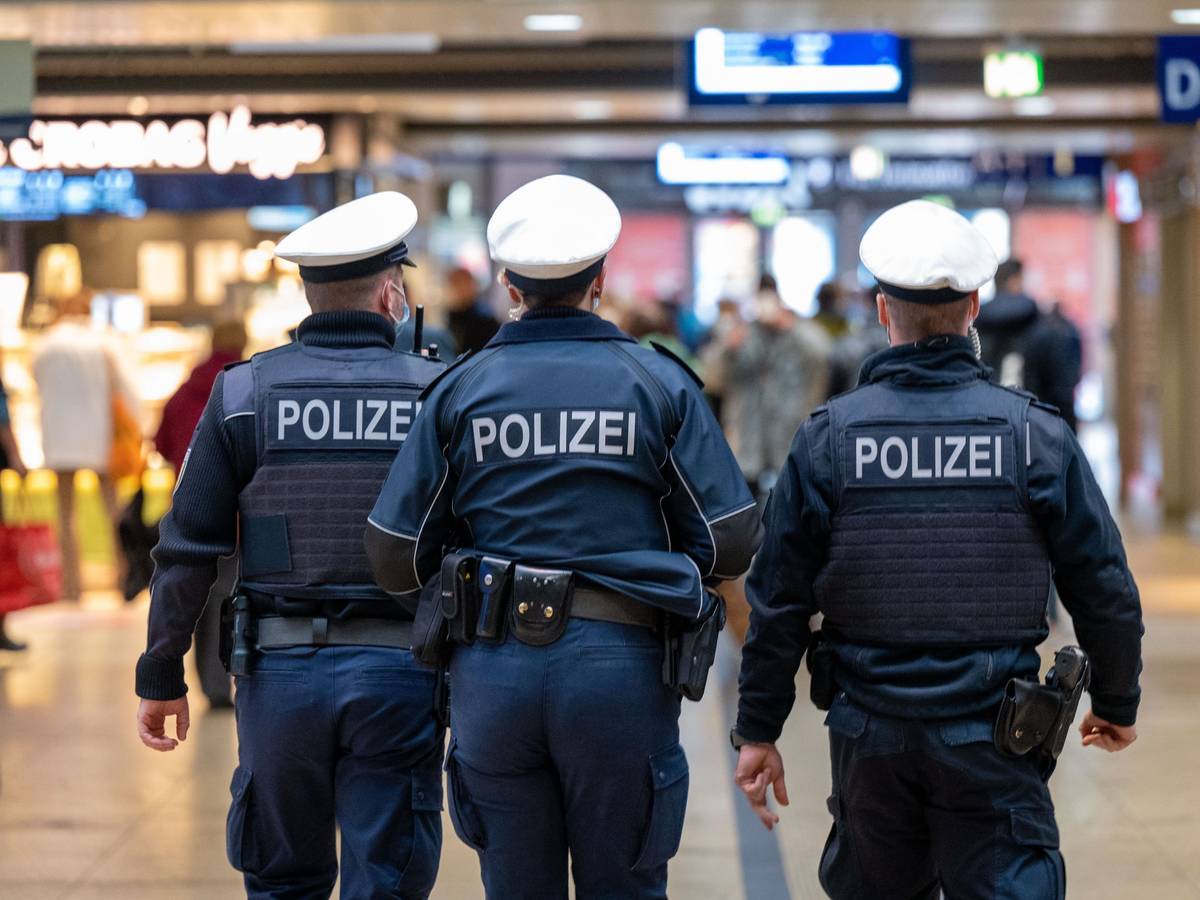 Drei Polizeibeamte laufen durch den Kölner Hauptbahnhof.