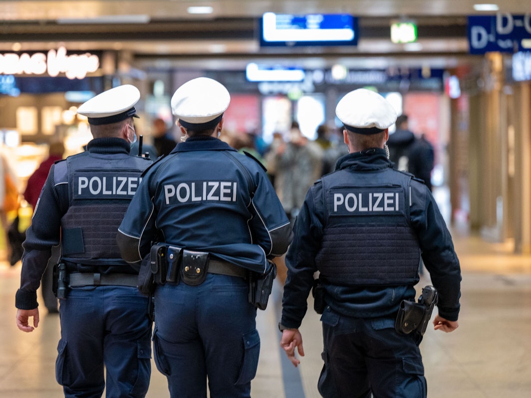 Drei Polizeibeamte laufen durch den Kölner Hauptbahnhof.