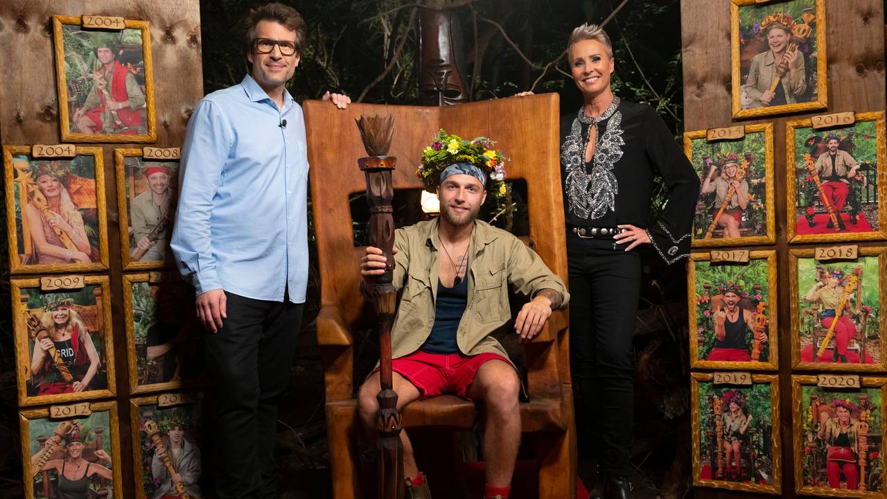 In diesem vom Fernsehsender RTL zur Verfügung gestellten Bild sitzt der neue "Dschungelkönig" Filip Pavlovic (M) auf seinem Thron. Daneben stehen die Moderatoren der Sendung Daniel Hartwich (l) und Sonja Zietlow. Pavlovic hat das Finale des RTL-Dschungelcamp 2022 gewonnen.