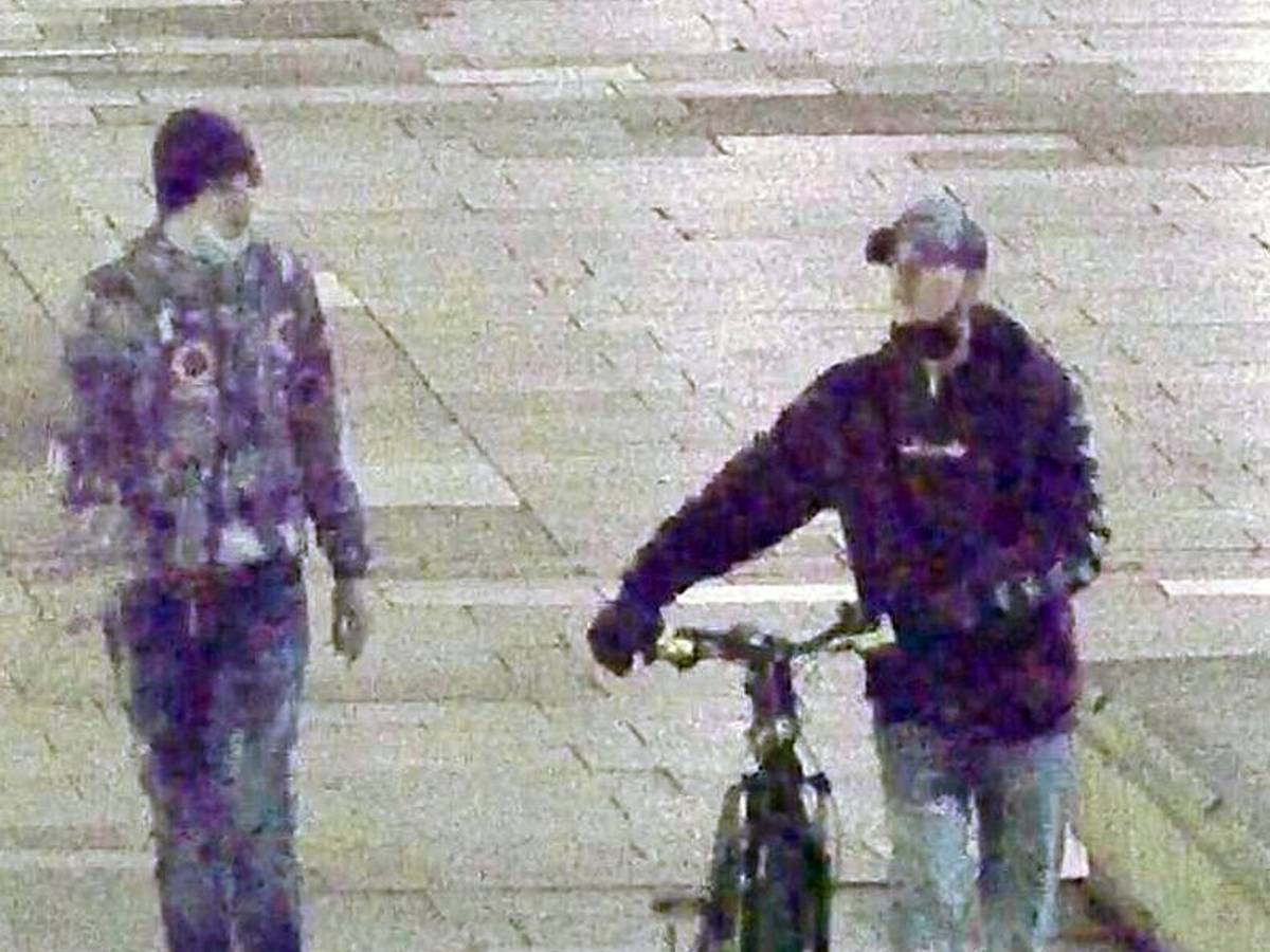 Zwei Männer, einer mit Fahrrad, gehen nebeneinander.