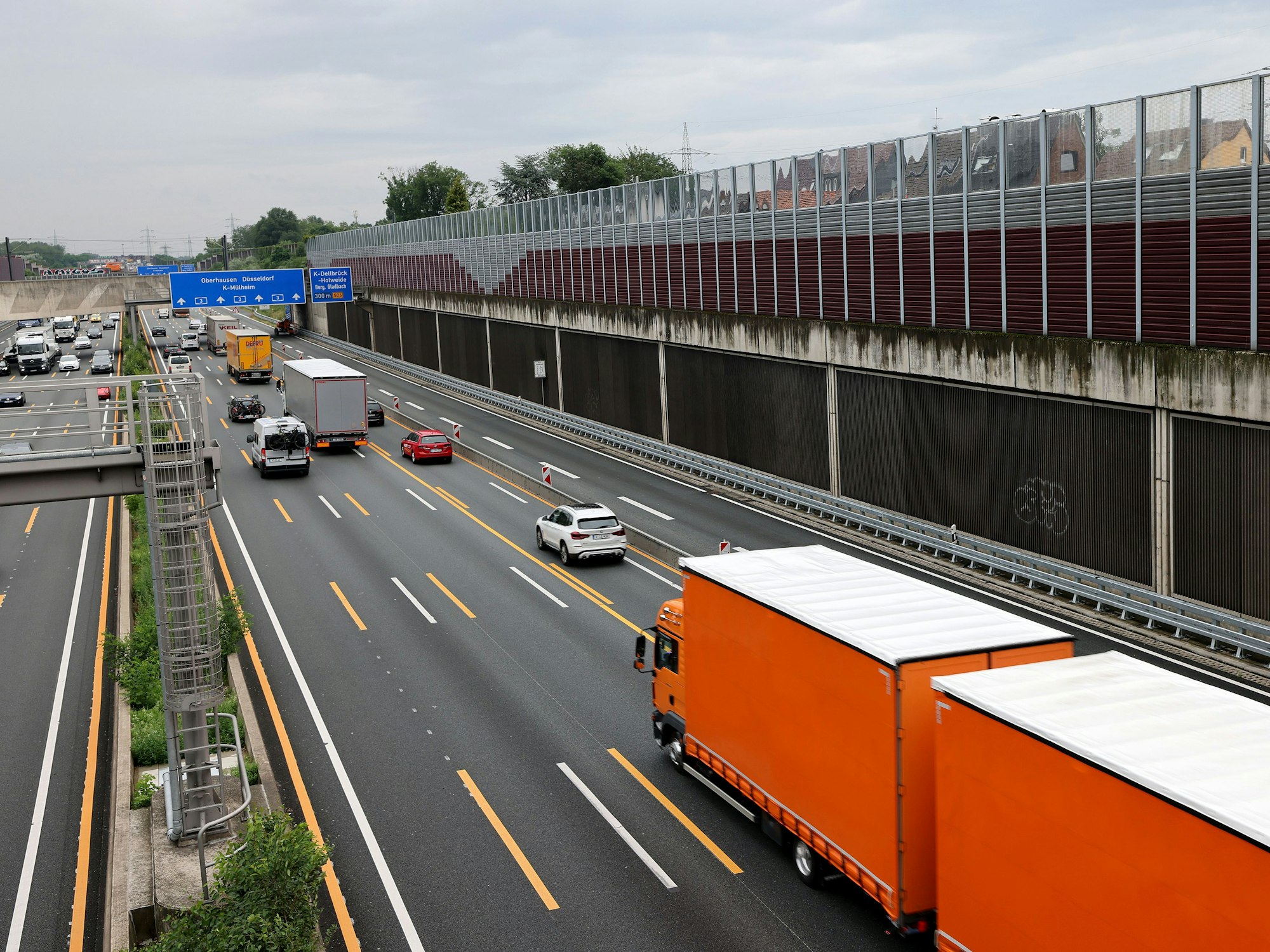 Kraftfahrzeuge fahren auf der A3 bei Köln an Schallschutzwänden vorbei.