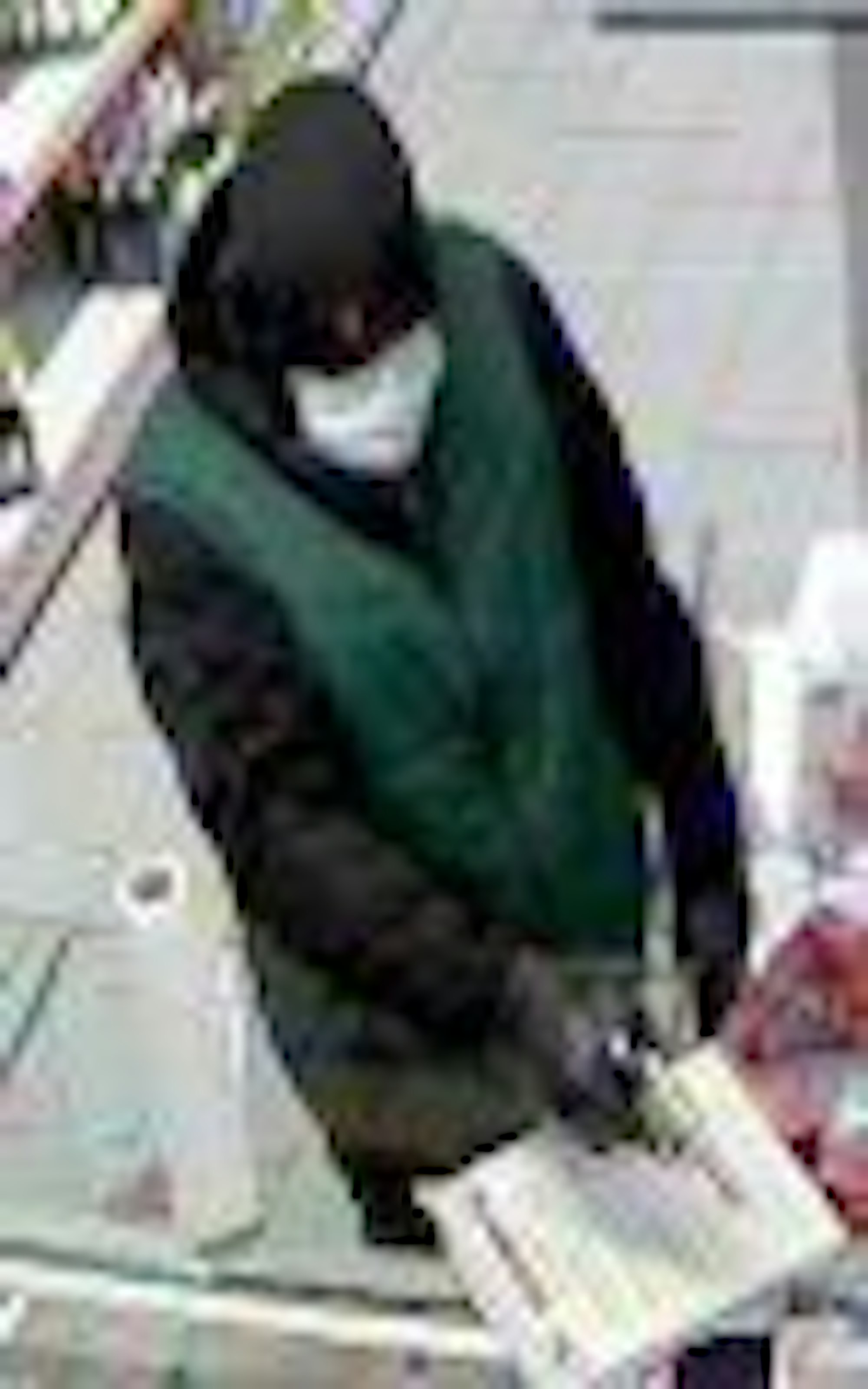 Der Täter mit der grünen Weste bedroht die Angestellte mit einem Revolver.