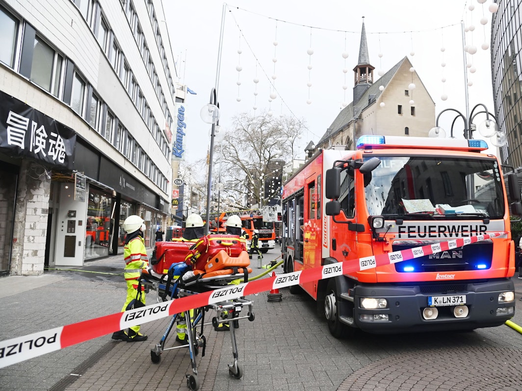 Ein Feuerwehrfahrzeug sowie mehrere Einsatzkräfte stehen auf der Schildergasse, die Straße ist mit Flatterband zum Teil abgesperrt.