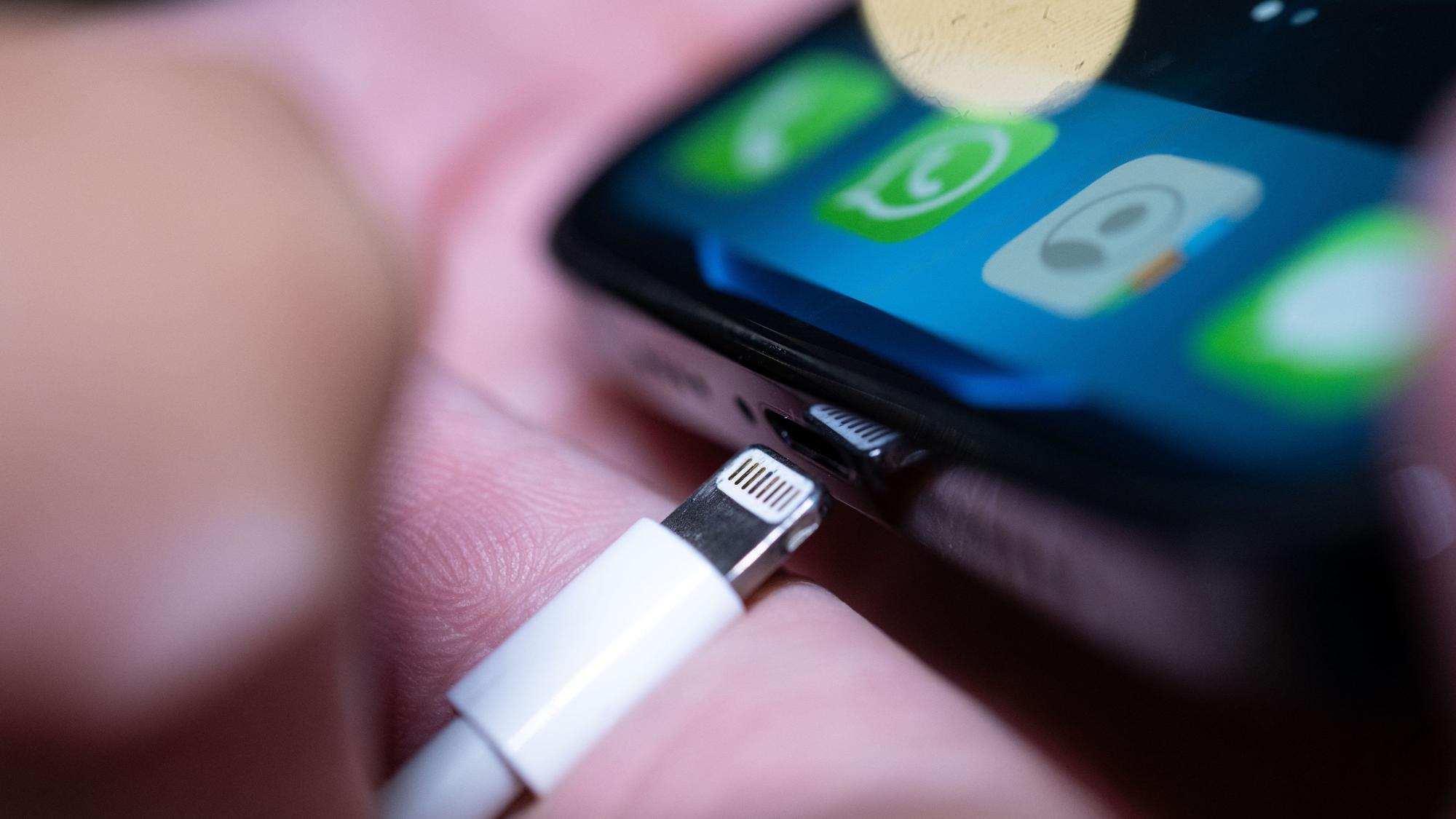 Ein Lightning-Ladestecker wird in ein Apple iPhone gesteckt.