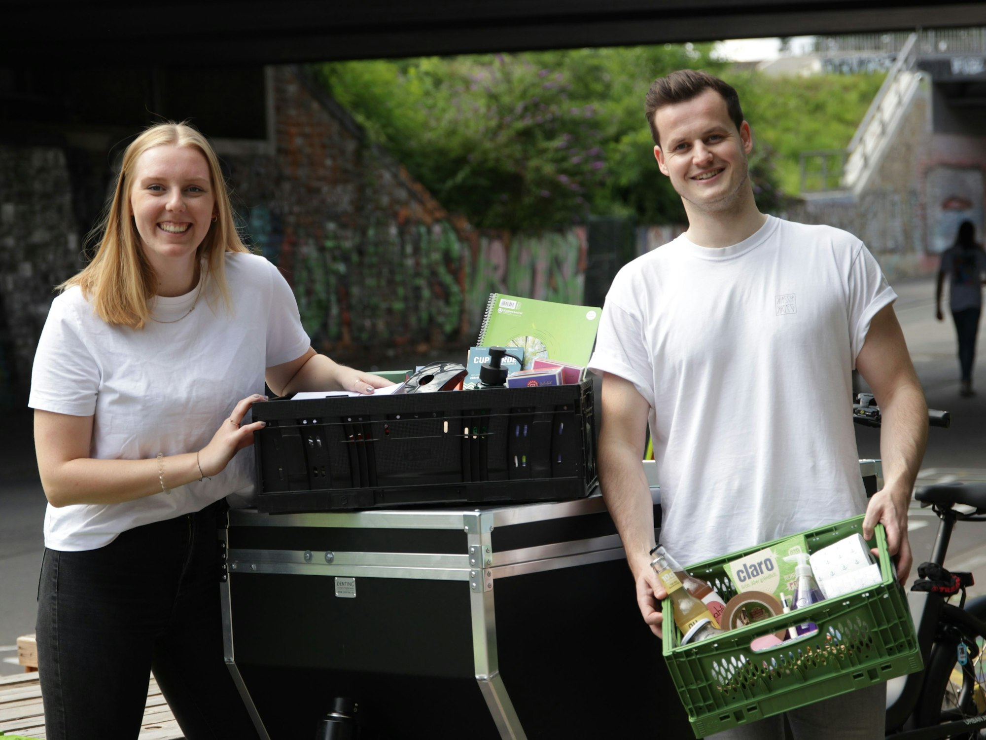 Anne Kronshage und Salomon Bohlen tragen Kisten und schauen in die Kamera.