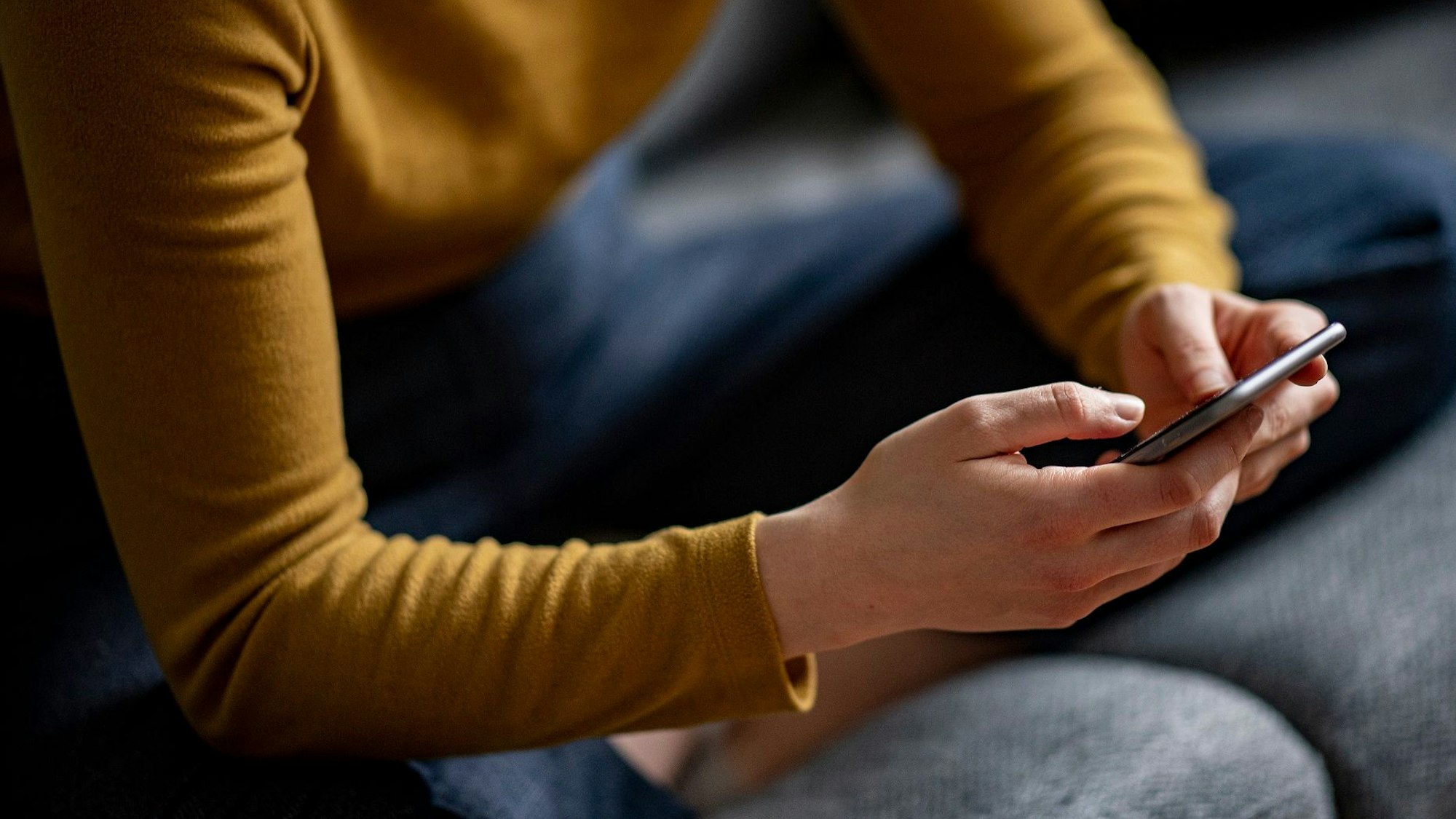Eine 15-Jährige wurde mit Bildern erpresst und im Internet vorgeführt. Sie nahm sich das Leben. Unser Symbolfoto zeigt eine junge Frau mit ihrem Smartphone in der Hand.