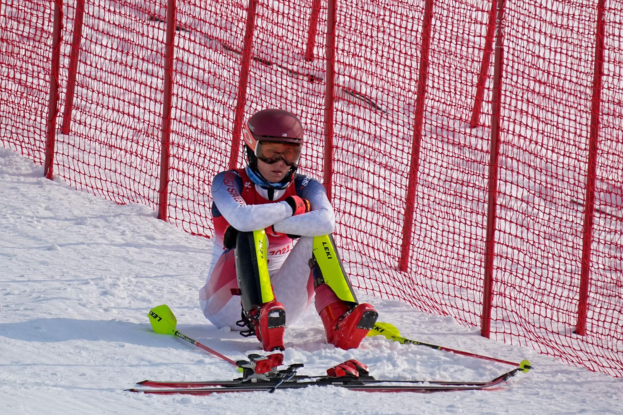 Mikaela Shiffrin sitzt nach ihrem Slalom-Aus frustriert im olympischen Schnee.