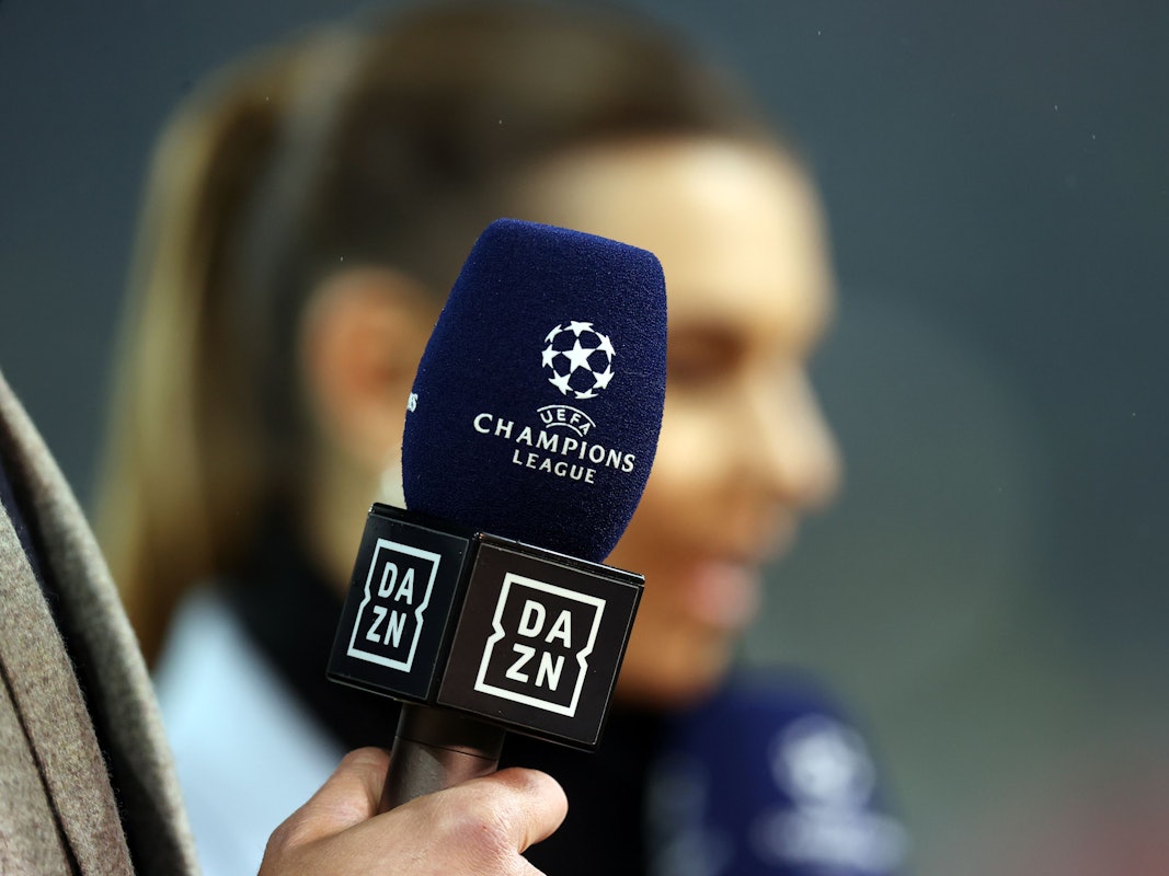 Ein Mikrofon mit den Logos von DAZN und der Champions League bei einer Live-Übertragung.