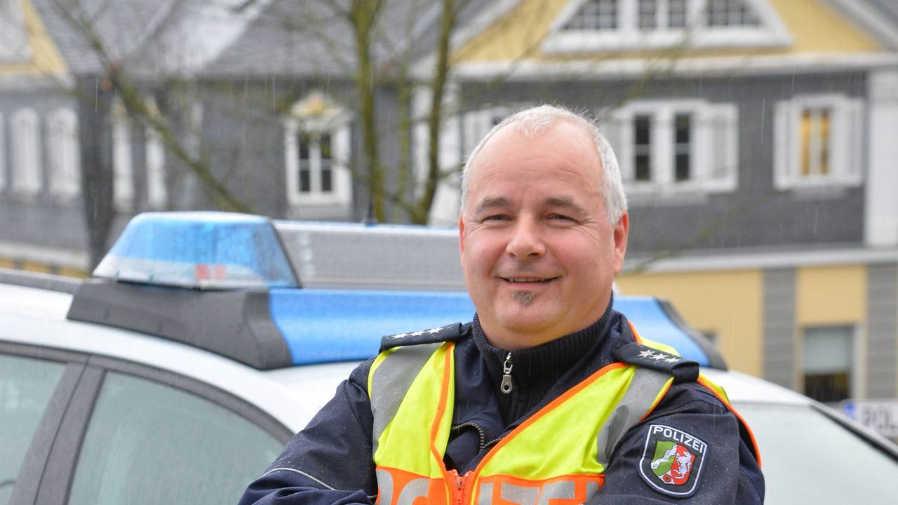Polizist Rolf Stangenberg
vor einem Polizei-Auto.