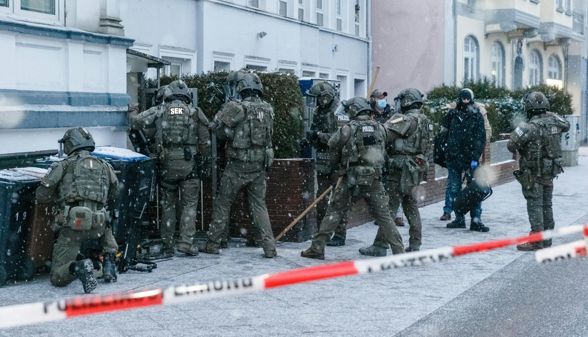Beamte eines Spezialeinsatzkommandos (SEK) der Polizei stürmen eine Wohnung.