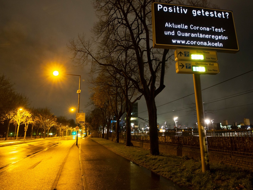 Ein Display an der Rheinuferstraße weist auf eine Internetseite der Stadt zu den Corona-Regeln in hin.