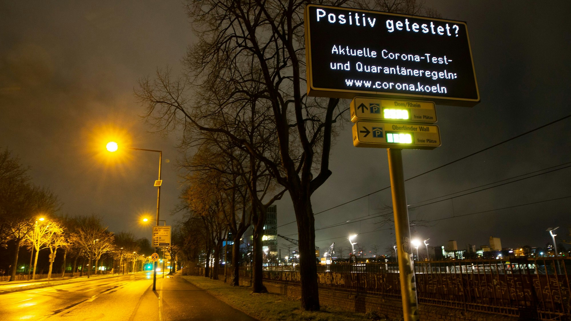 Ein Display an der Rheinuferstraße weist auf eine Internetseite der Stadt zu den Corona-Regeln in hin.