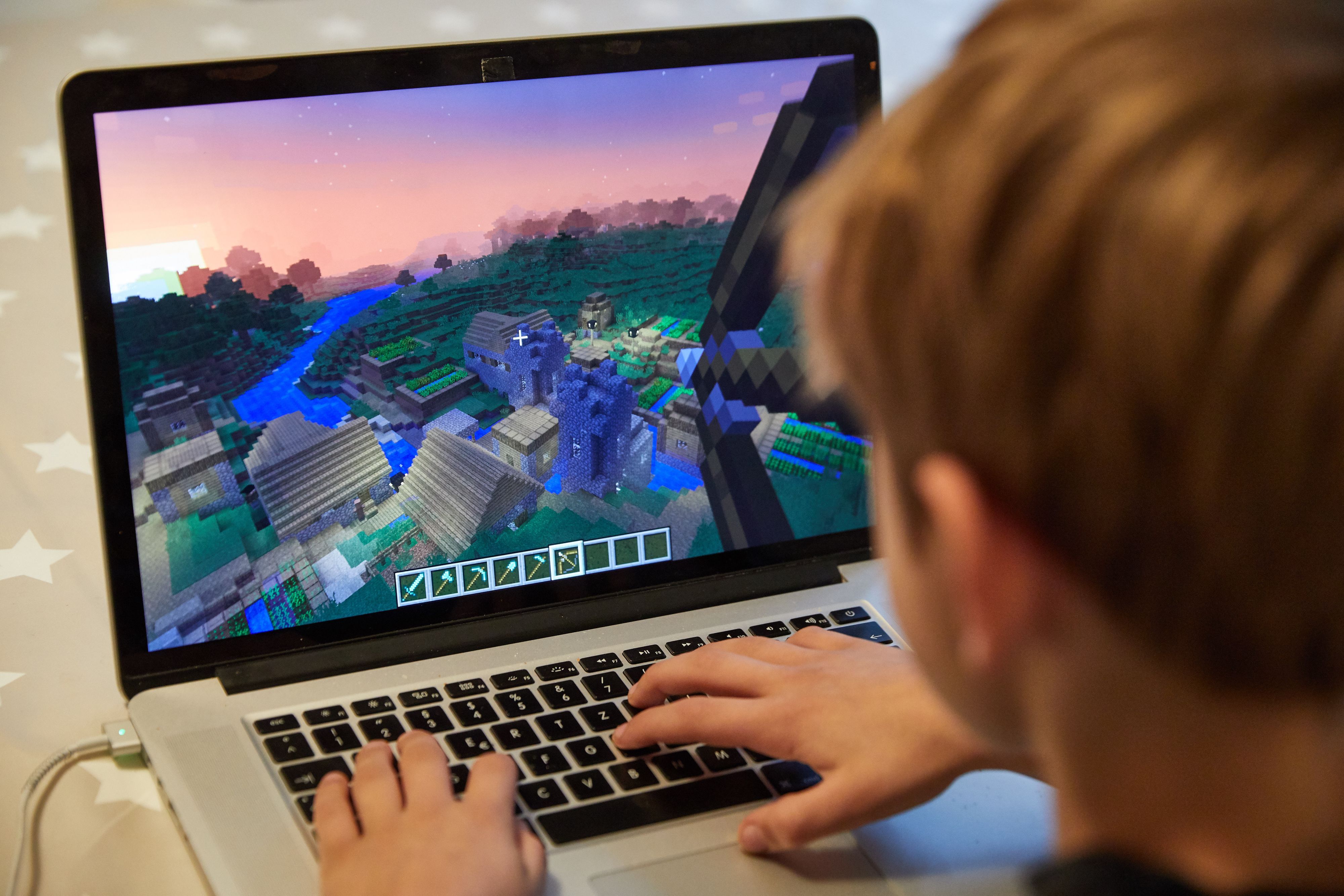 Ein Junge spielt auf einem Laptop das Open-World-Computerspiel „Minecraft“ (Symolfoto).