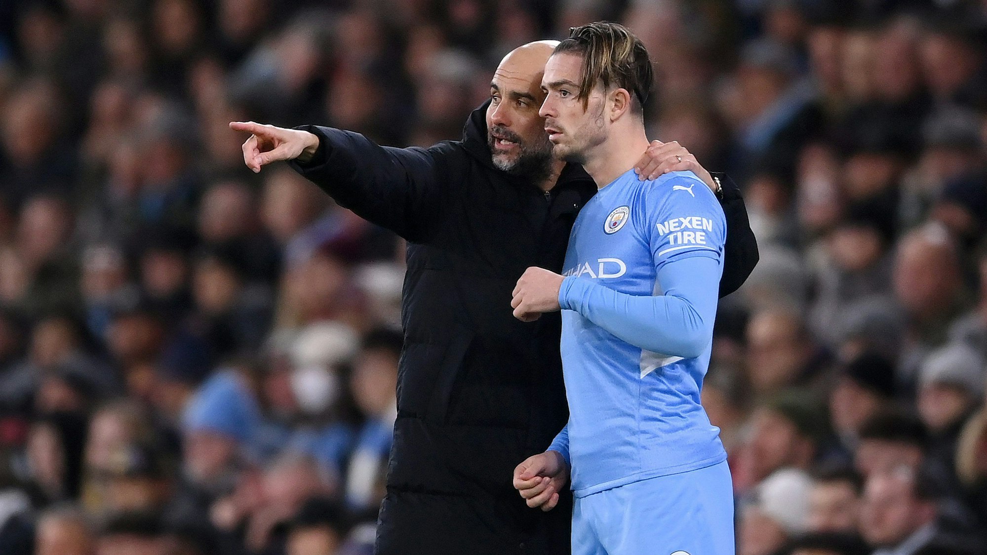 Pep Guardiola gibt Jack Grealish Anweisungen.