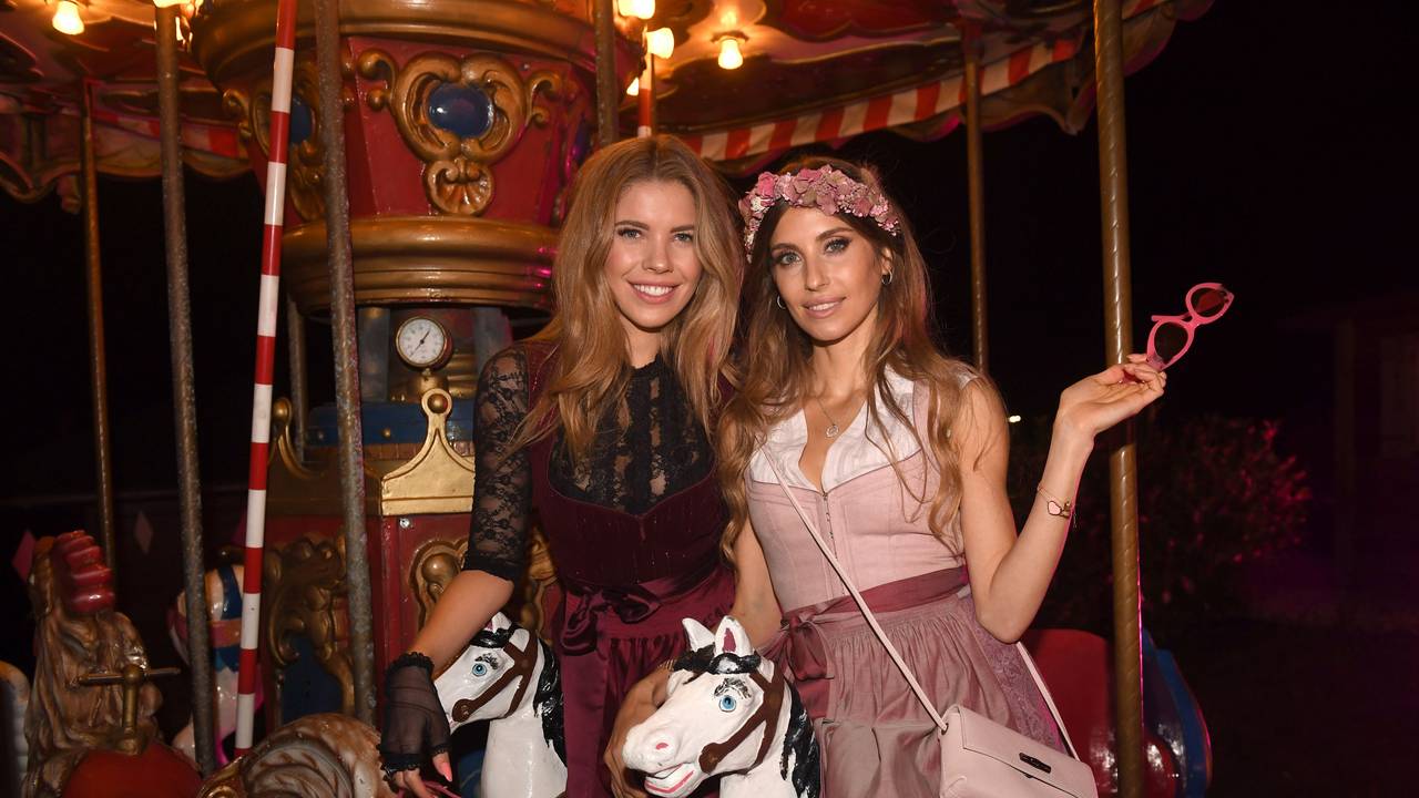 Die Popsängerin Victoria Swarovski (l) und Cathy Hummels sitzen bei der "Wiesn Wiesn Charity Night", die unter dem Motto «Ich liebe das Leben» in der «Käfer Alm» an der Galopprennbahn München gefeiert wurde, auf einem Karussell.