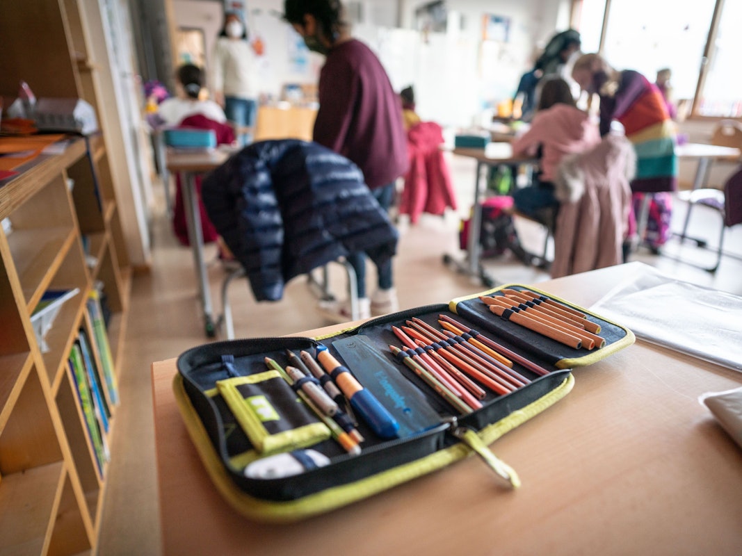 Mappe mit Stiften in einem Klassenraum.