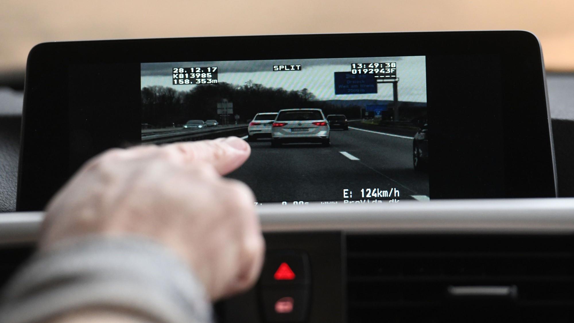 Auf einem Display sieht man vorausfahrende Fahrzeuge auf der Autobahn.