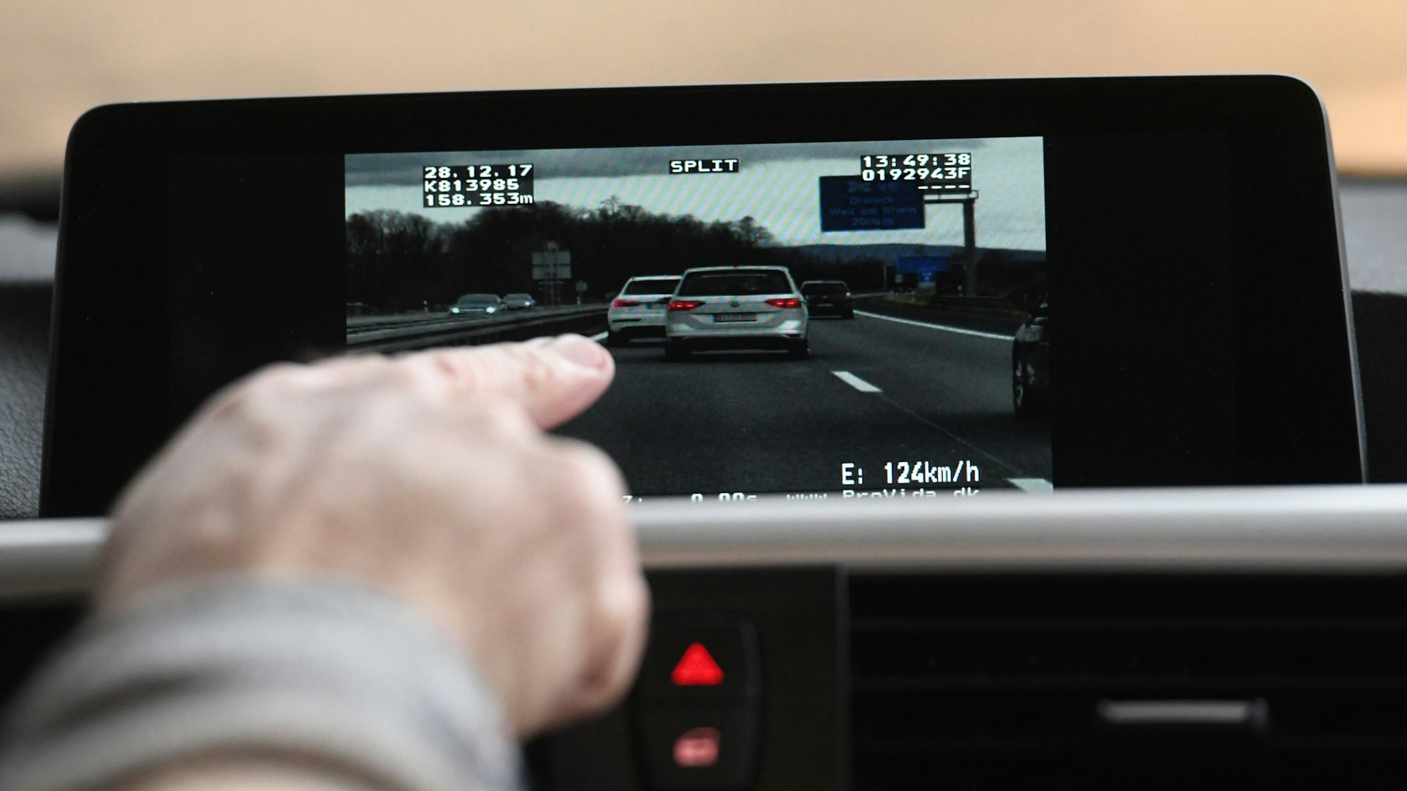 Auf einem Display sieht man vorausfahrende Fahrzeuge auf der Autobahn.