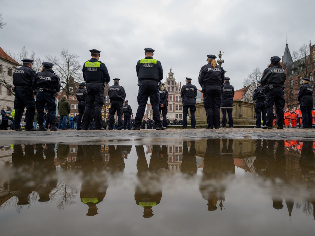 Polizisten stehen auf dem Marktplatz zusammen, um eine Schweigeminute für die in Rheinland-Pfalz getöteten Polizisten abzuhalten.