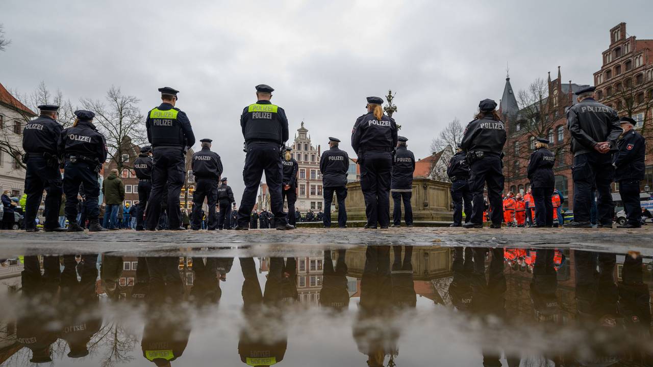 Polizisten stehen auf dem Marktplatz zusammen, um eine Schweigeminute für die in Rheinland-Pfalz getöteten Polizisten abzuhalten.