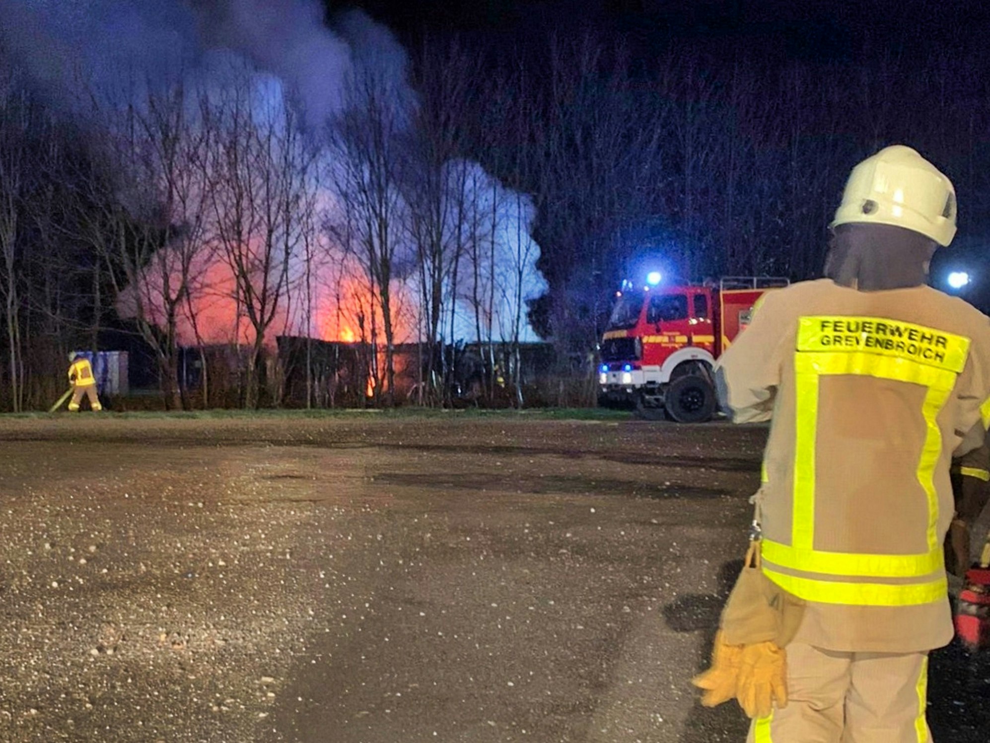 Feuerwehr bei einem Brandeinsatz an einem Waldstück.