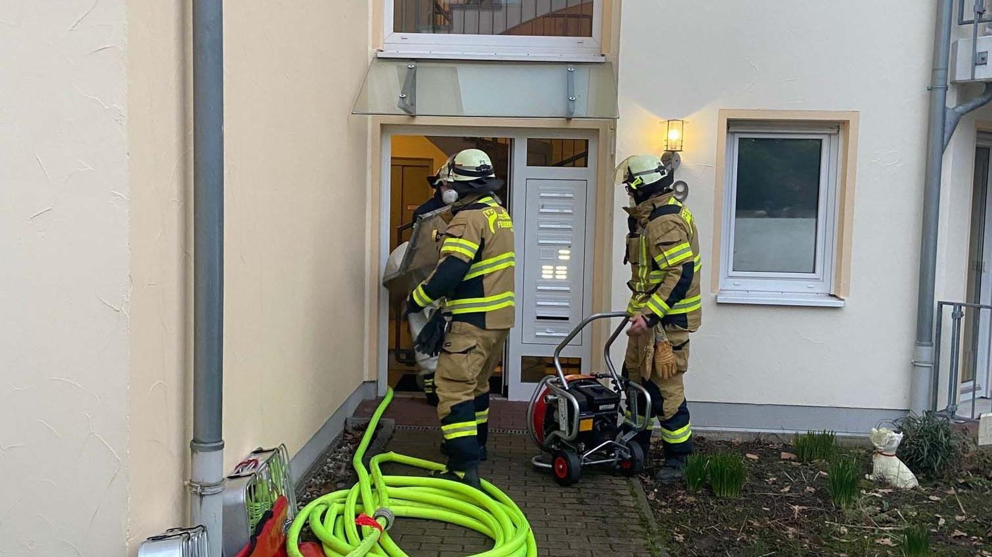 Feuerwehrmänner bei einem Einsatz an einem Mehrfamilienhaus.
