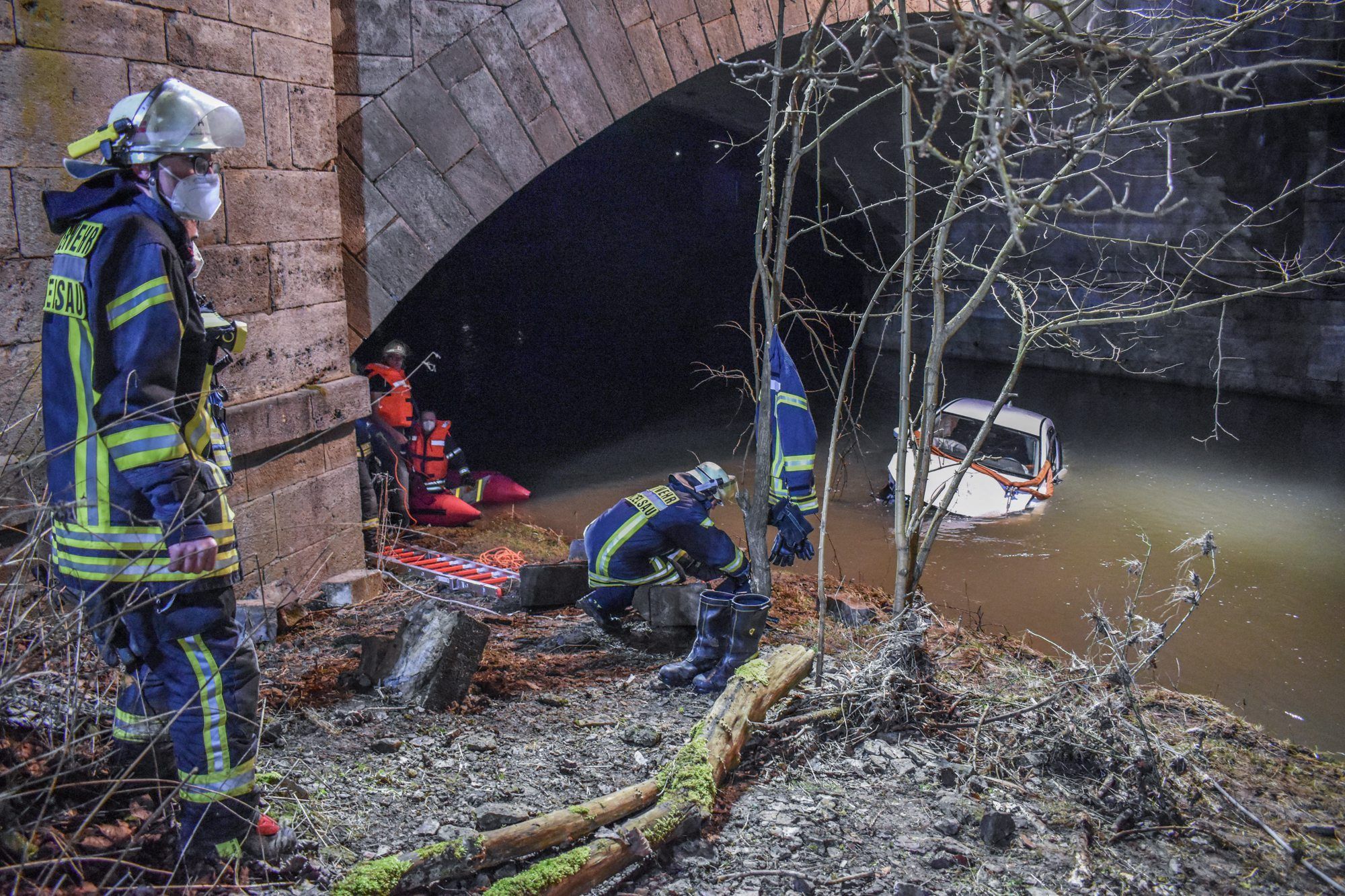 Ein PKW liegt unterhalb einer Brücke am Fluss Kocher in Künzelsau. Eine Autofahrerin ist mit ihrem Wagen in einen Fluss gestürzt und dabei leicht verletzt worden.